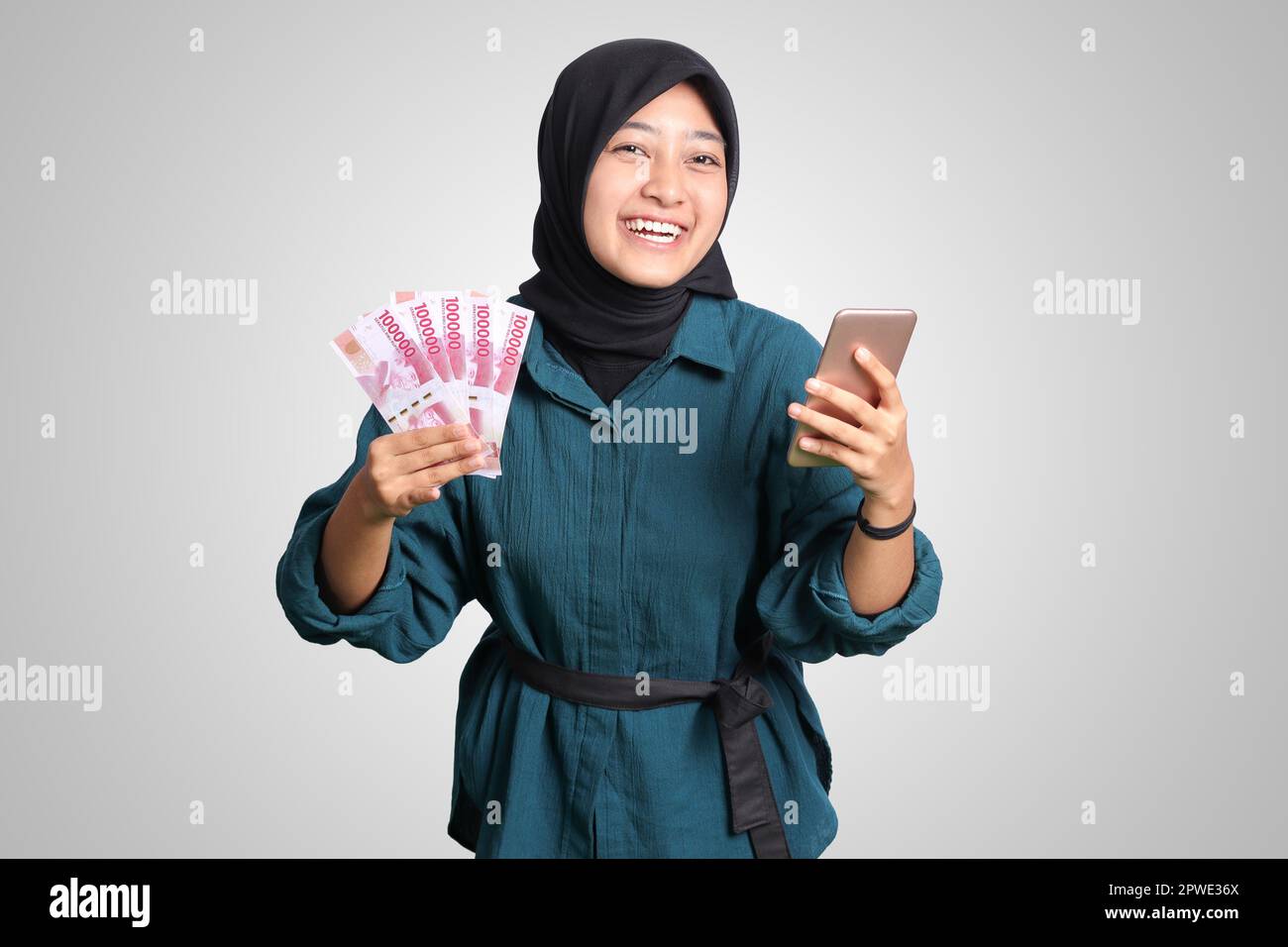 Portrait of excited Asian hijab woman in casual outfit showing one ...