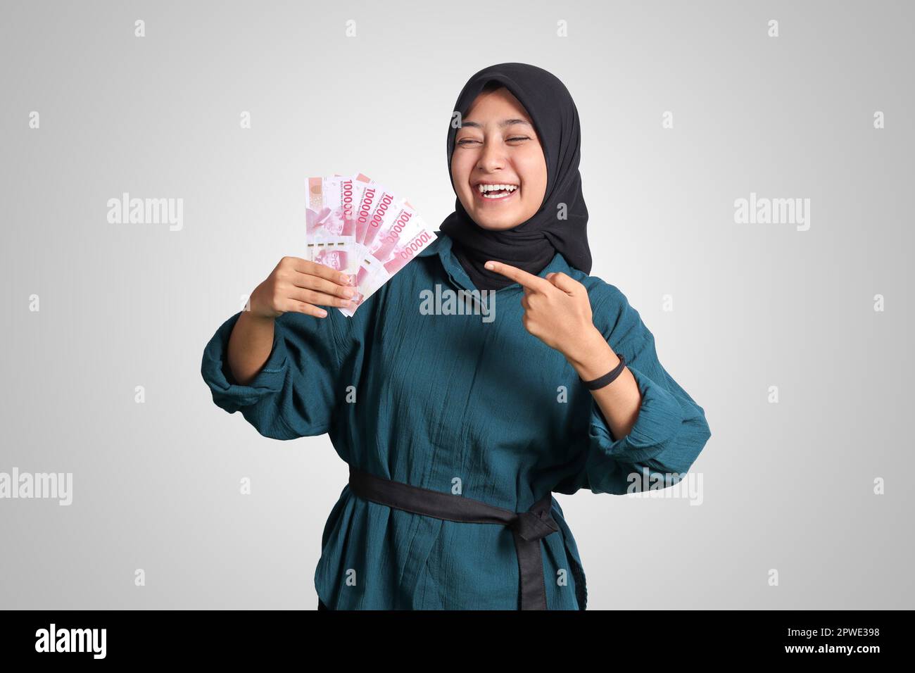 Portrait of excited Asian hijab woman in casual outfit showing and ...