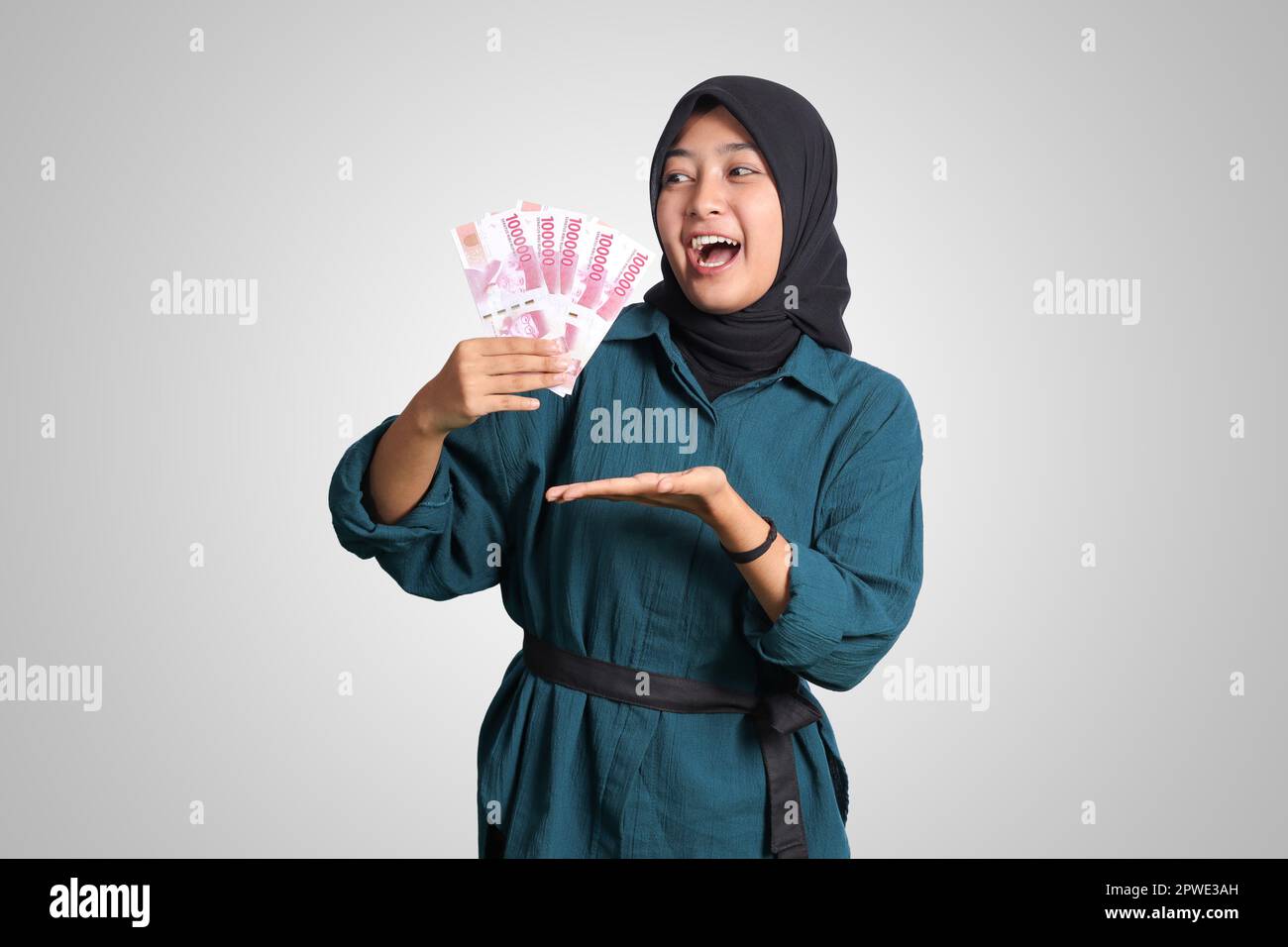 Portrait of excited Asian hijab woman in casual outfit showing and ...
