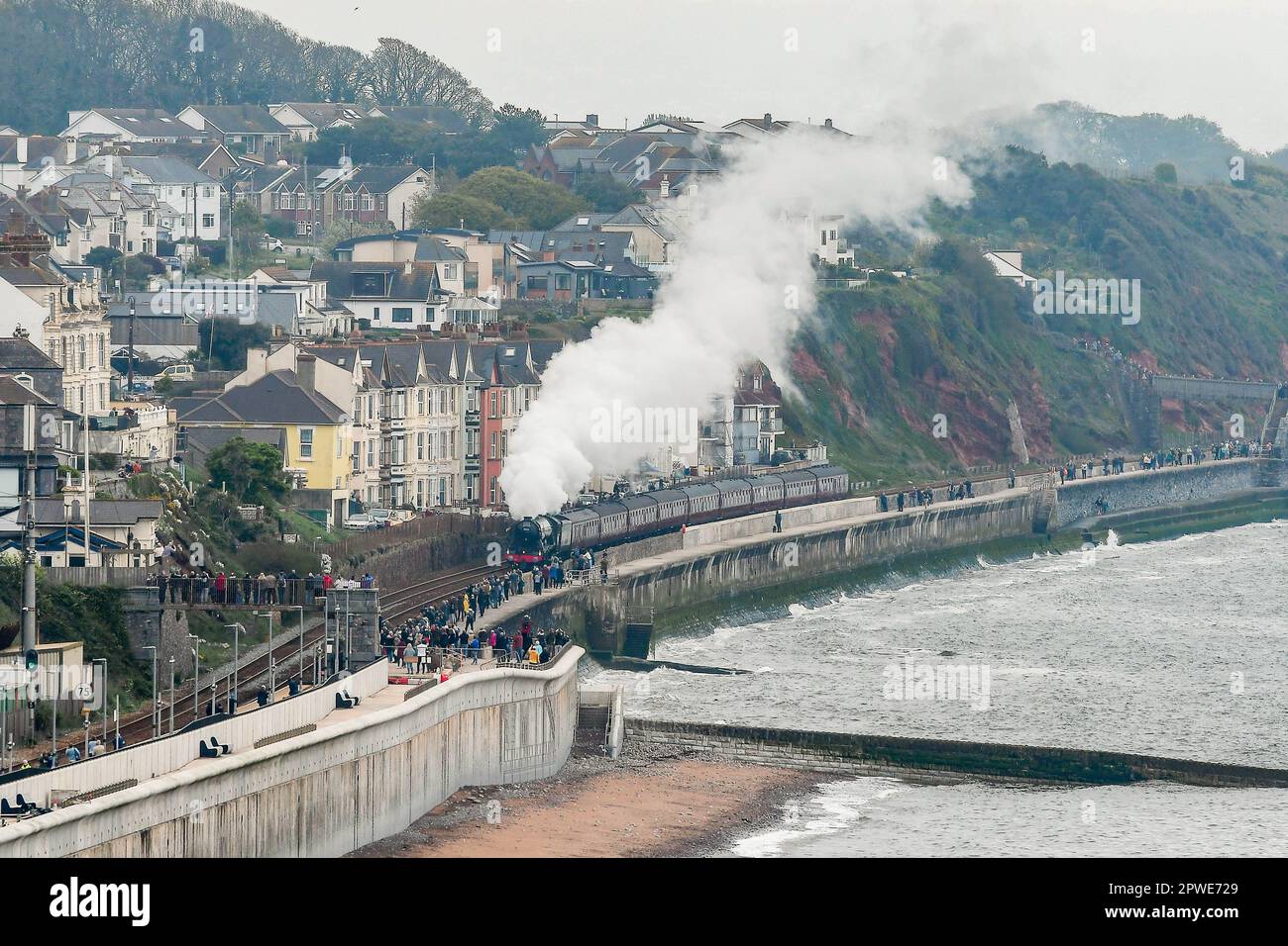 Dawlish, Devon, UK.  30th April 2023. Steam enthusiasts line the sea wall as No.60103 the Flying Scotsman races through Dawlish in Devon as it heads towards Plymouth on its way to Cornwall during the iconic steam locomotives centenary celebrations.  Picture Credit: Graham Hunt/Alamy Live News Stock Photo