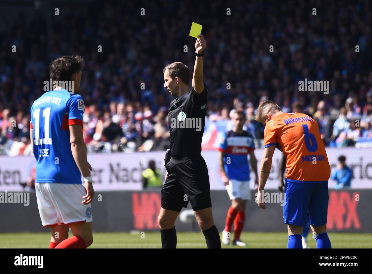Kiel, Germany. 30th Apr, 2023. Soccer: 2. Bundesliga, Holstein Kiel - Darmstadt 98, Matchday 30, Holstein Stadium. Referee Florian Heft (M) cautions Darmstadt's Marvin Mehlem (r) after a foul. Credit: Gregor Fischer/dpa - IMPORTANT NOTE: In accordance with the requirements of the DFL Deutsche Fußball Liga and the DFB Deutscher Fußball-Bund, it is prohibited to use or have used photographs taken in the stadium and/or of the match in the form of sequence pictures and/or video-like photo series./dpa/Alamy Live News Stock Photo