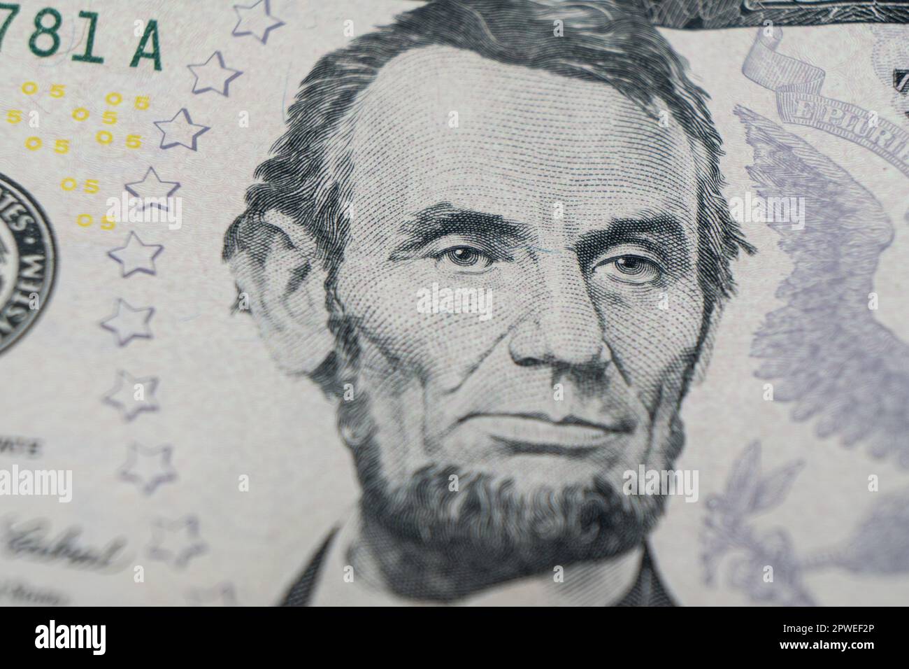 Macro shot Portrait of Abraham Lincoln on the one five dollar bill. Background of the money. 5 dollar bill with Abraham Lincoln eyes macro shot. Money Stock Photo
