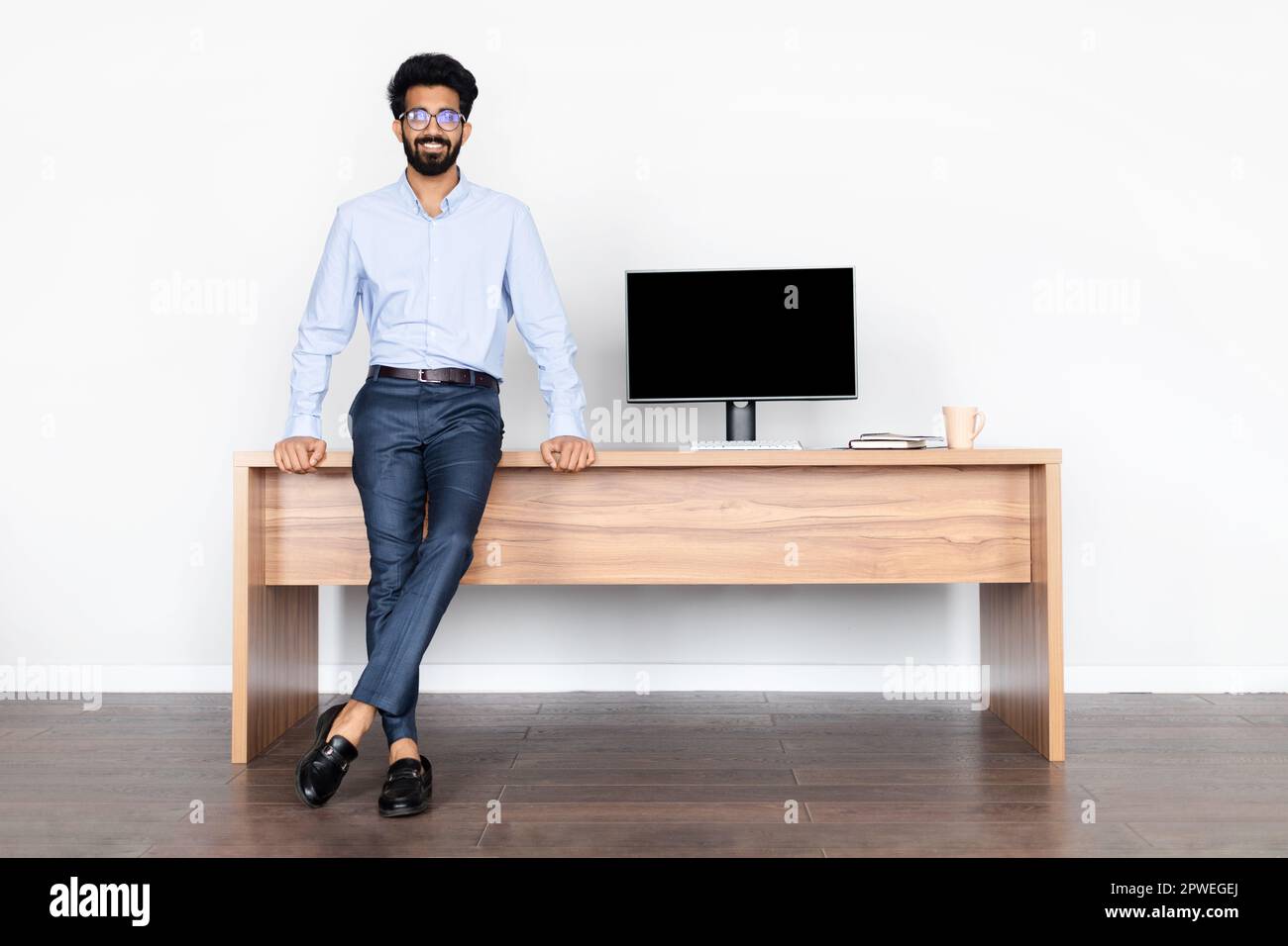 Cheerful handsome middle eastern man posing at office Stock Photo