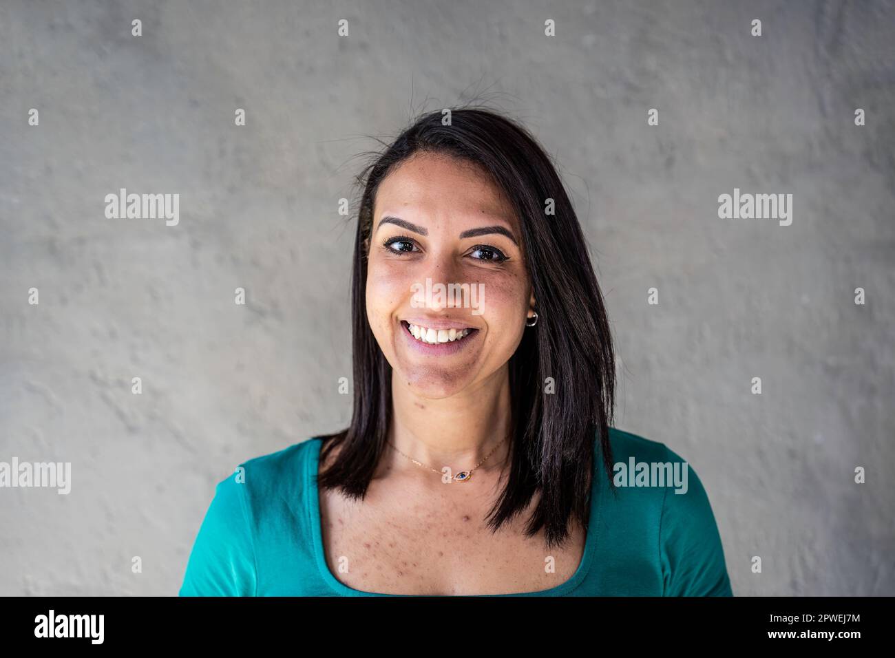 Portrait of happy north african woman - Confident and smiling young moroccan woman with smooth hair and peculiar teeth having fun while posing in fron Stock Photo