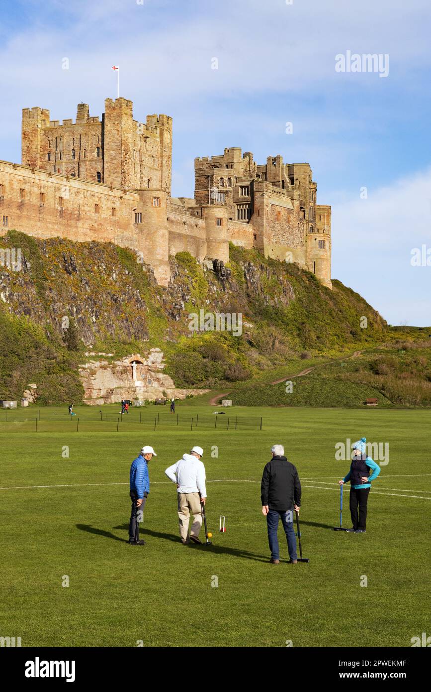 Bamburgh Castle Northumberland UK; The local club playing croquet on the green beside the 11th century castle; Bamburgh village, Northumberland UK Stock Photo