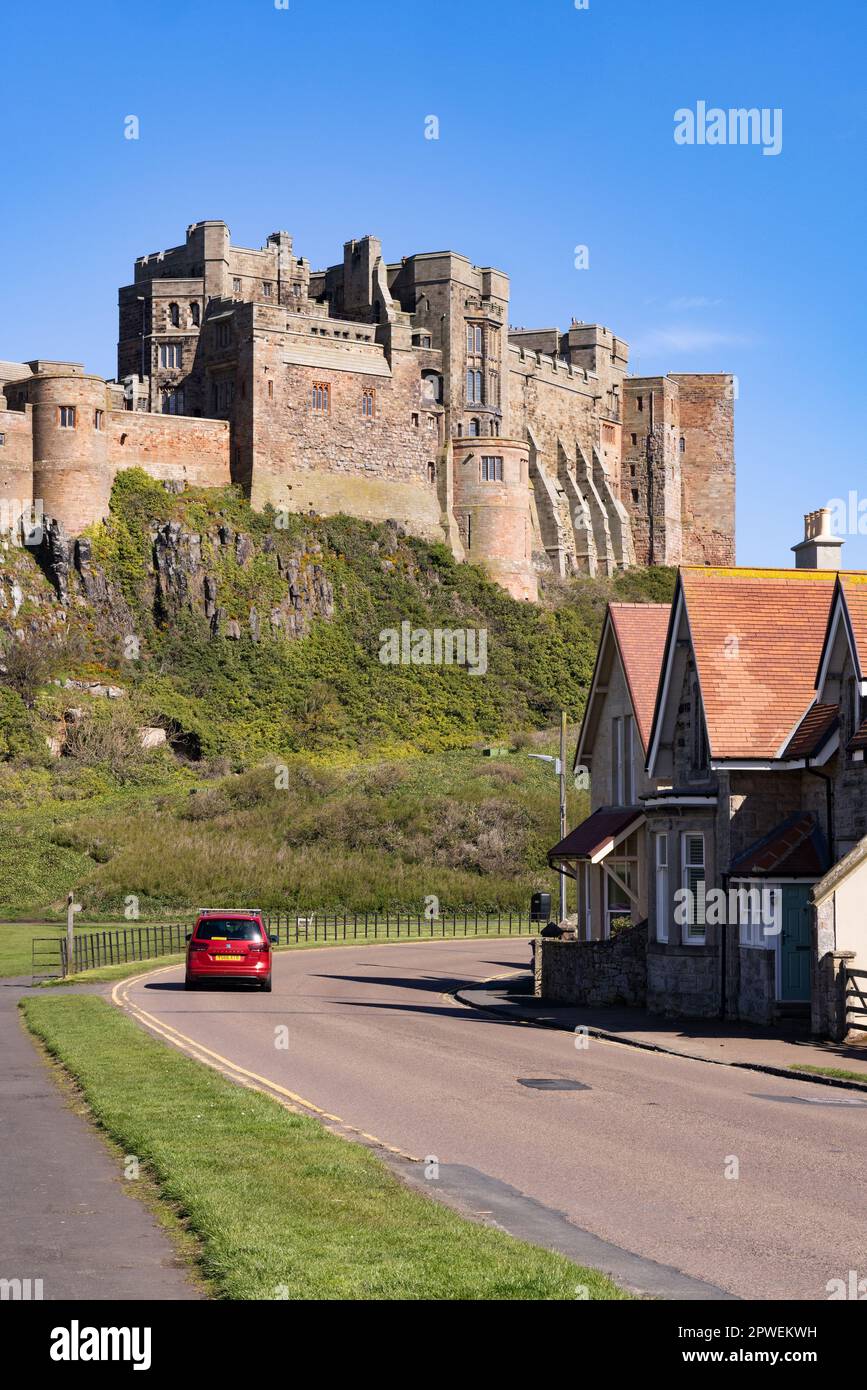 Northumberland driving; car driving through Bamburgh and Bamburgh Castle on a tourist route, Bamburgh, Northumberland UK. UK tourism. UK travel. Stock Photo