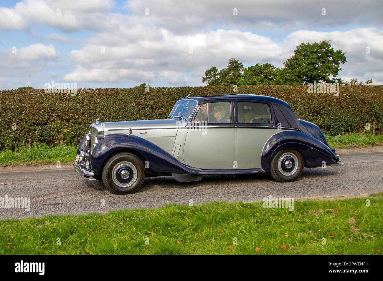 1954 50s fifties Bentley Blue Car Petrol 4566 cc, R-Type Standard Steel Saloon; Isolated classic car travelling on a country lane in Congleton, UK Stock Photo