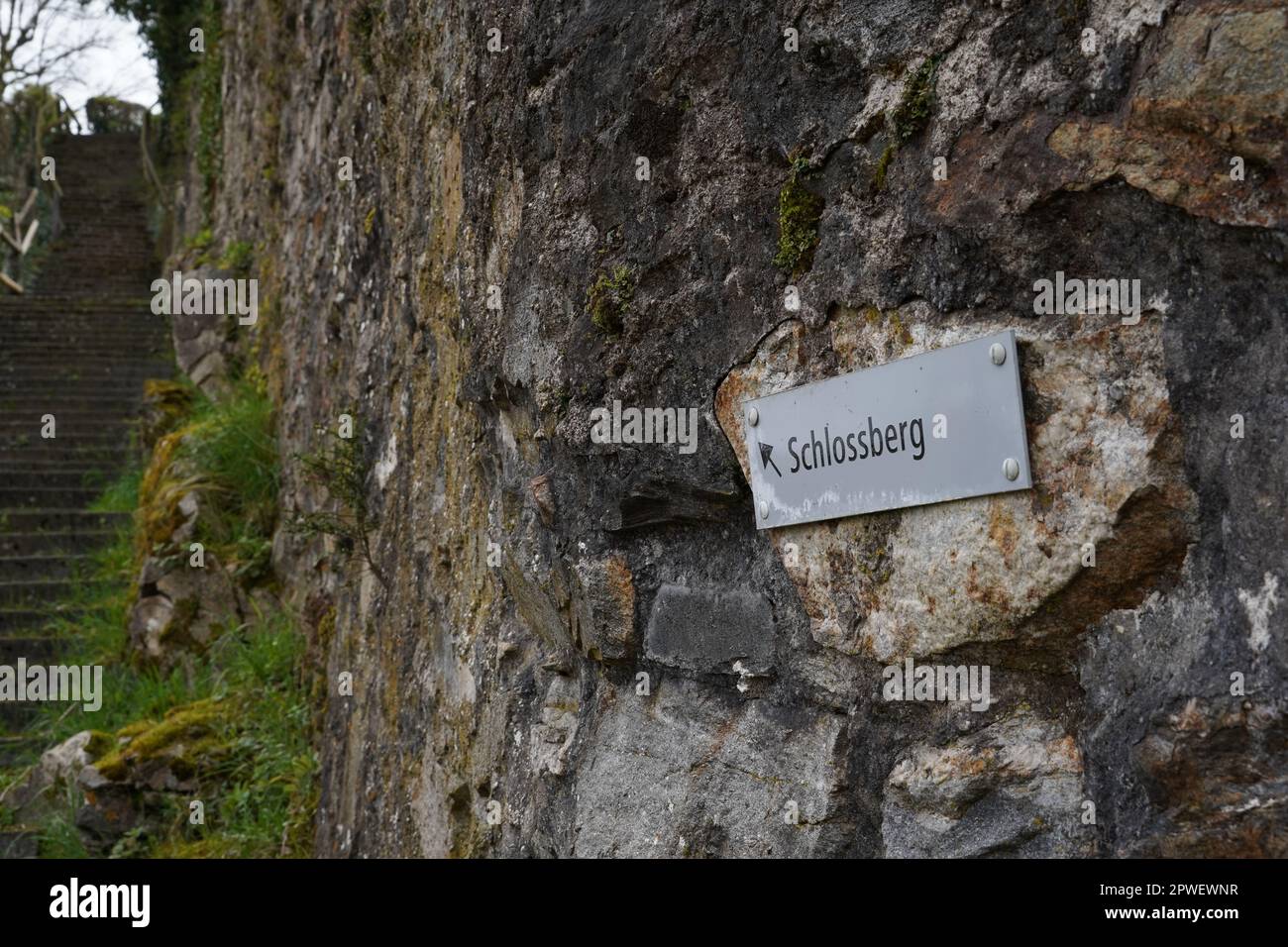 Stone wall with a metal shield with an arrow and an inscription in