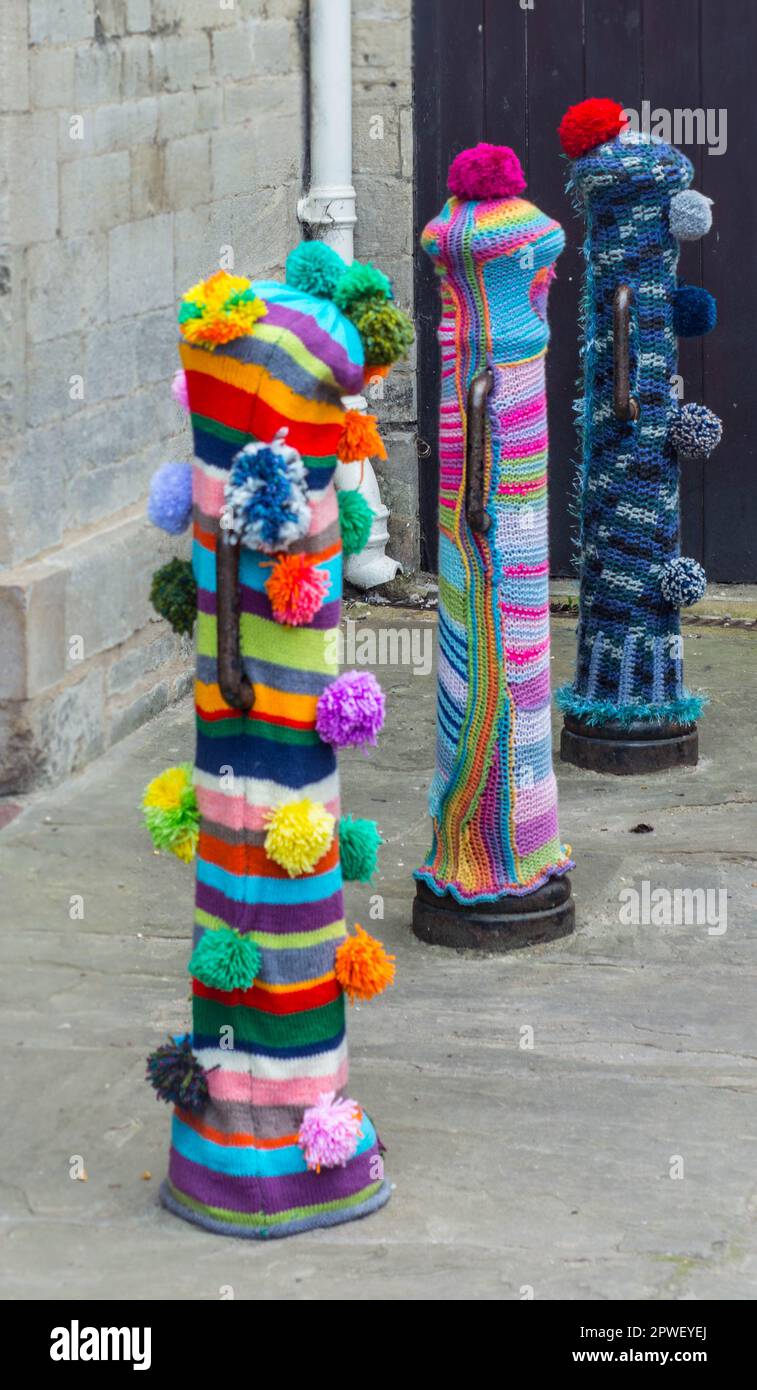 Three bollards displaying yarn bombing artwork in the Northamptonshire