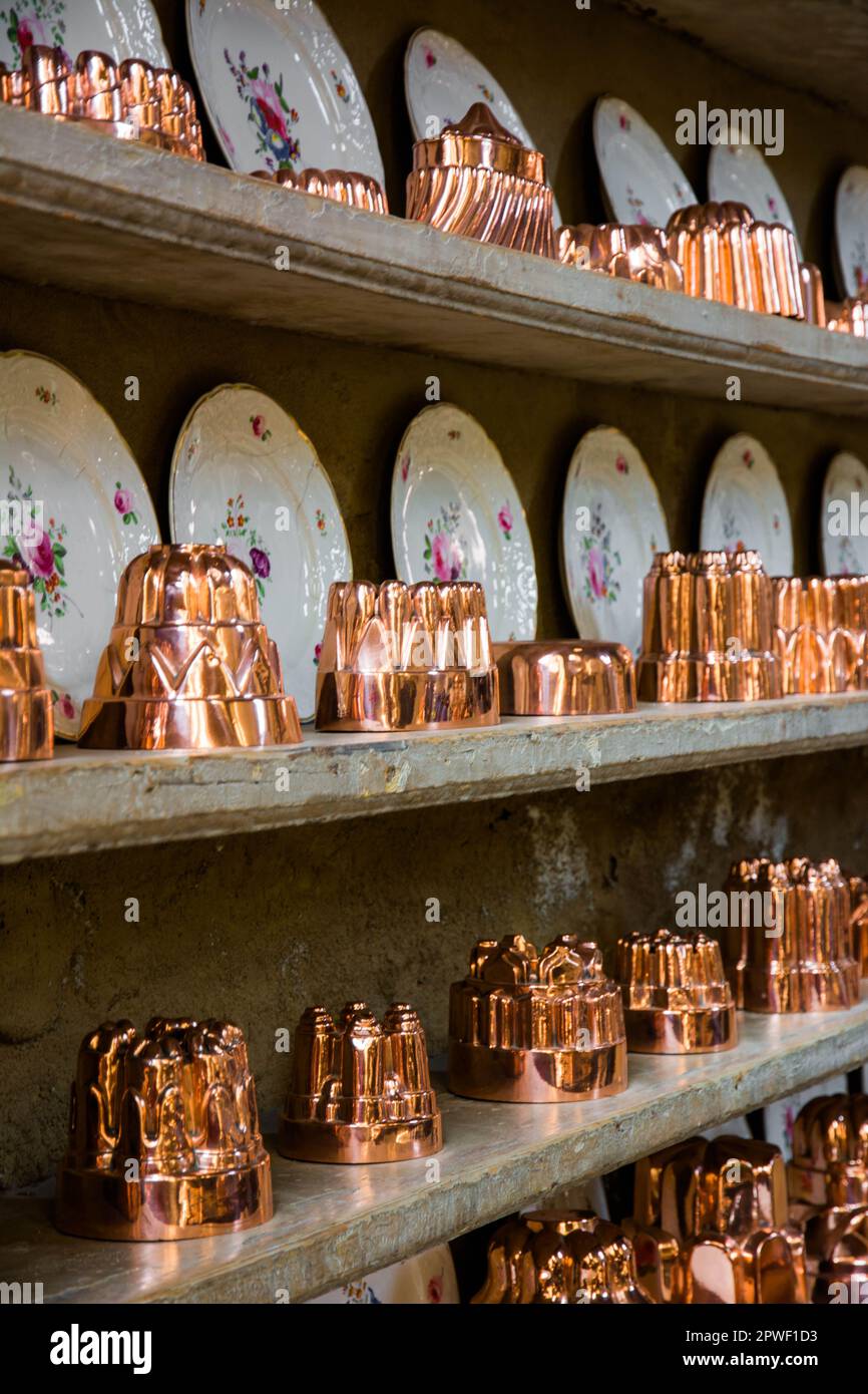 Burghley House and Estate interior pictures from the kitchen showing copper and brass cooking moulds and pans and plates Stock Photo