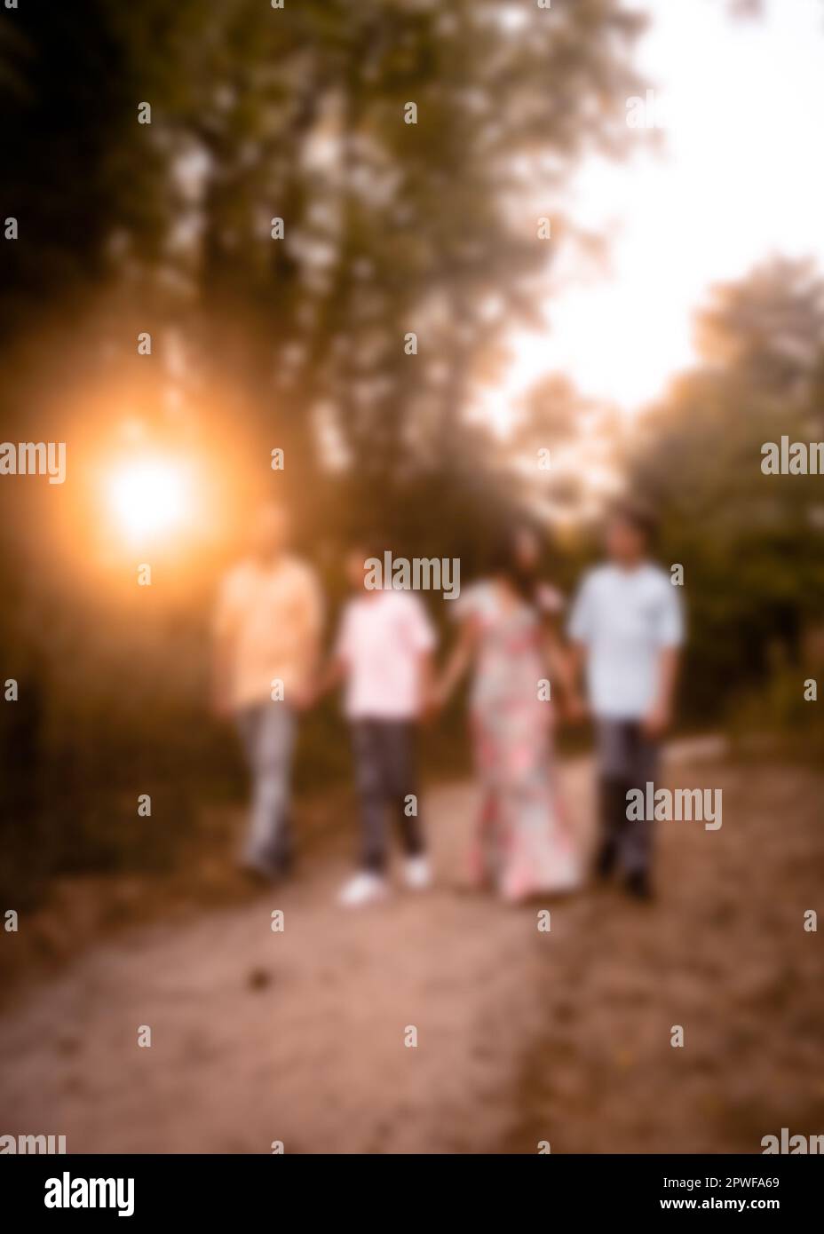 Defocused blur of family of four walking outdoors Stock Photo