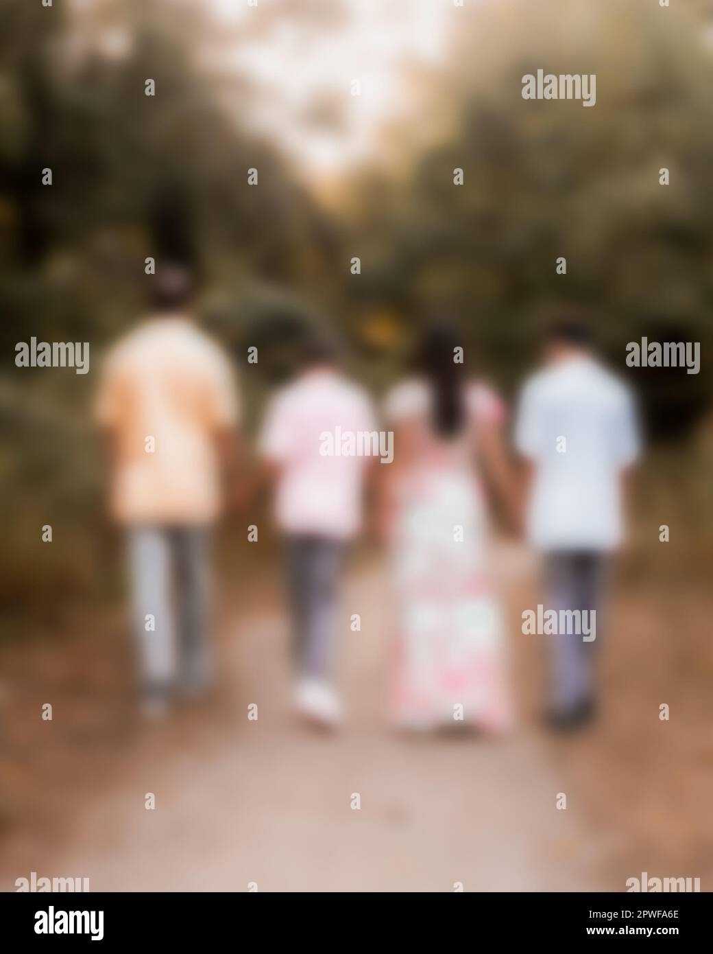 Defocused blur of family of four walking outdoors Stock Photo