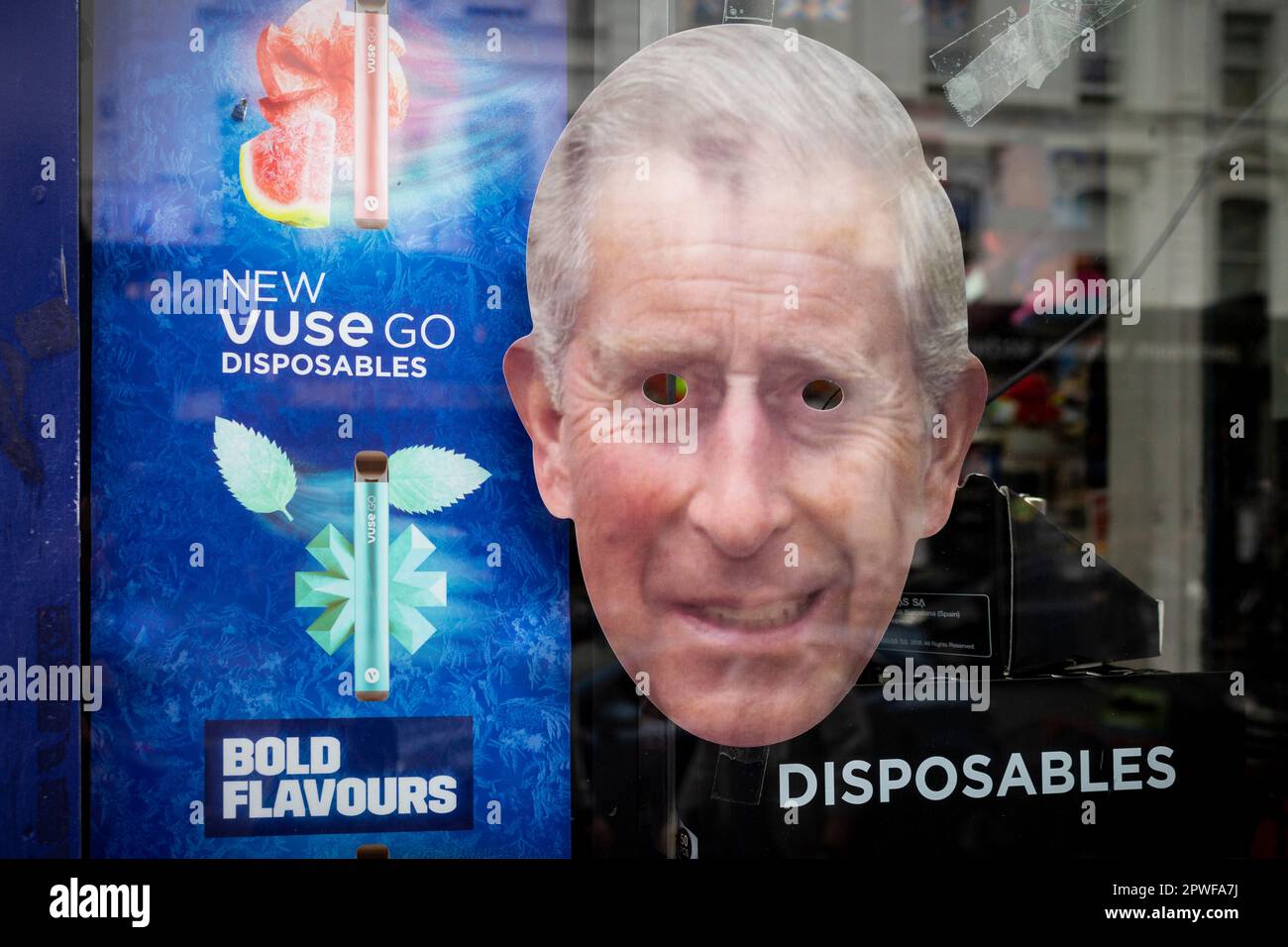 London, UK.  30 April 2023.  Royal memorabilia, including a King Charles facemask next to an advertisement for a vaping product, seen in the window of a souvenir shop in Paddington ahead of the coronation of King Charles III on 6 May.  Credit: Stephen Chung / Alamy Live News Stock Photo