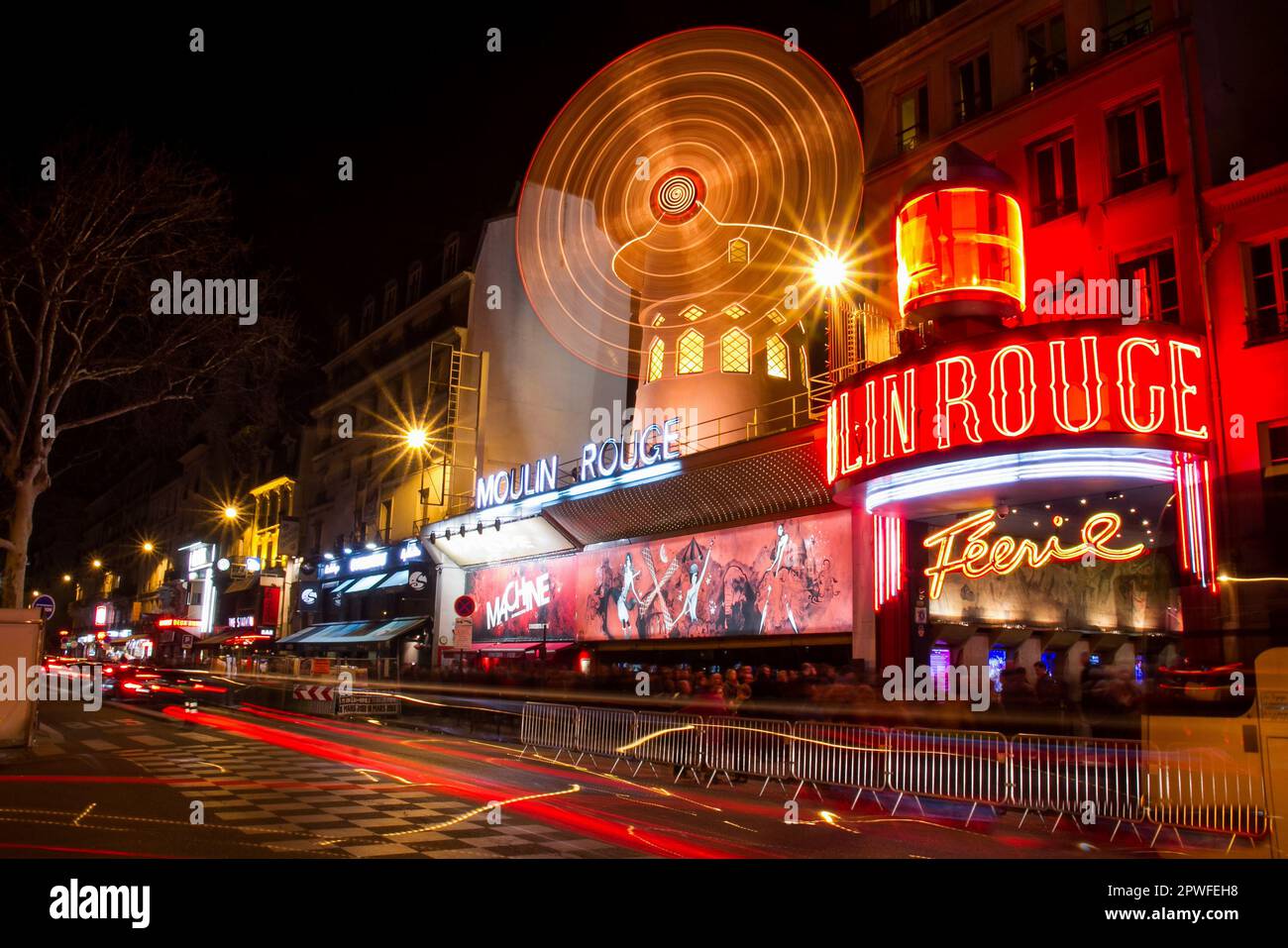 Facade of the Moulin Rouge cabaret in the entertainment district of Pigalle near Montmartre in Paris, France - Motion blur on an illuminated rotating Stock Photo