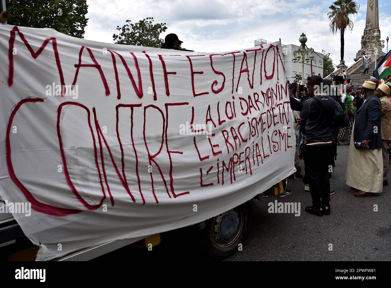 Marseille, France. 29th Apr, 2023. Protesters hang a banner expressing their opinion during the demonstration. Several people mostly the Comorian population, demonstrated in Marseille against the immigration law by the French government of Emmanuel Macron and supported by the Minister of Interior Gérald Darmanin, and against the 'Wuambushu' security operation in Mayotte. Credit: SOPA Images Limited/Alamy Live News Stock Photo