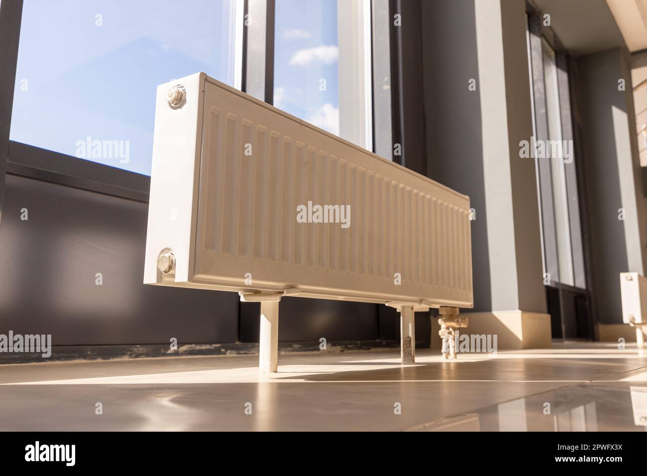 Vertically installed central heating radiator on the floor at the fully