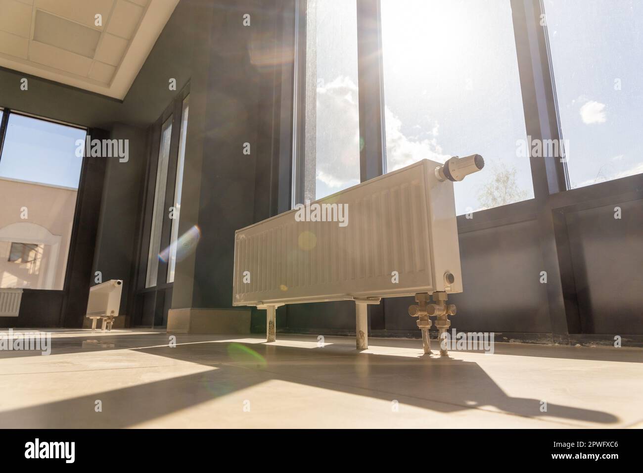 Vertically installed central heating radiator on the floor at the fully ...