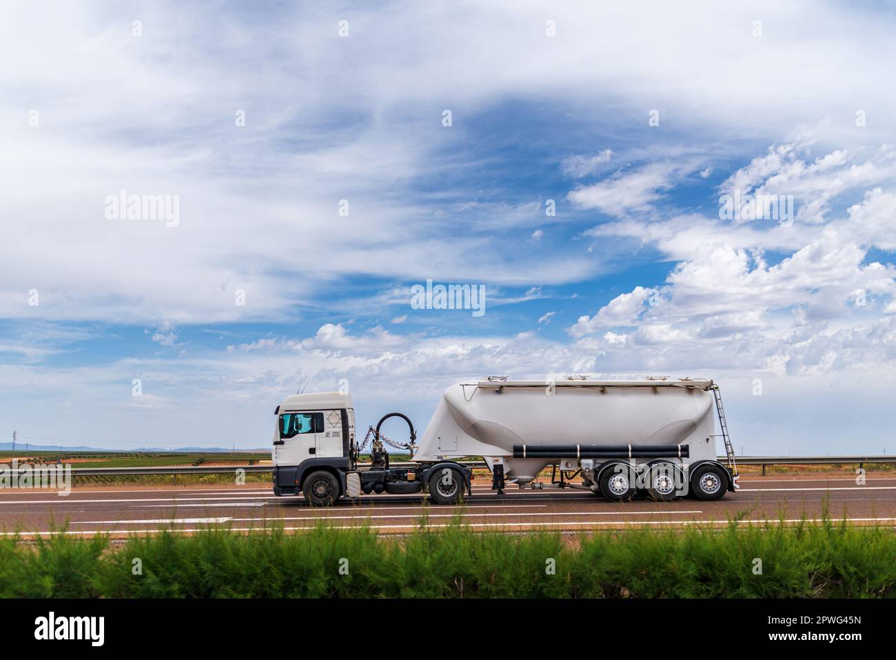 Tanker truck for the transport of bulk cement circulating on a highway. Stock Photo
