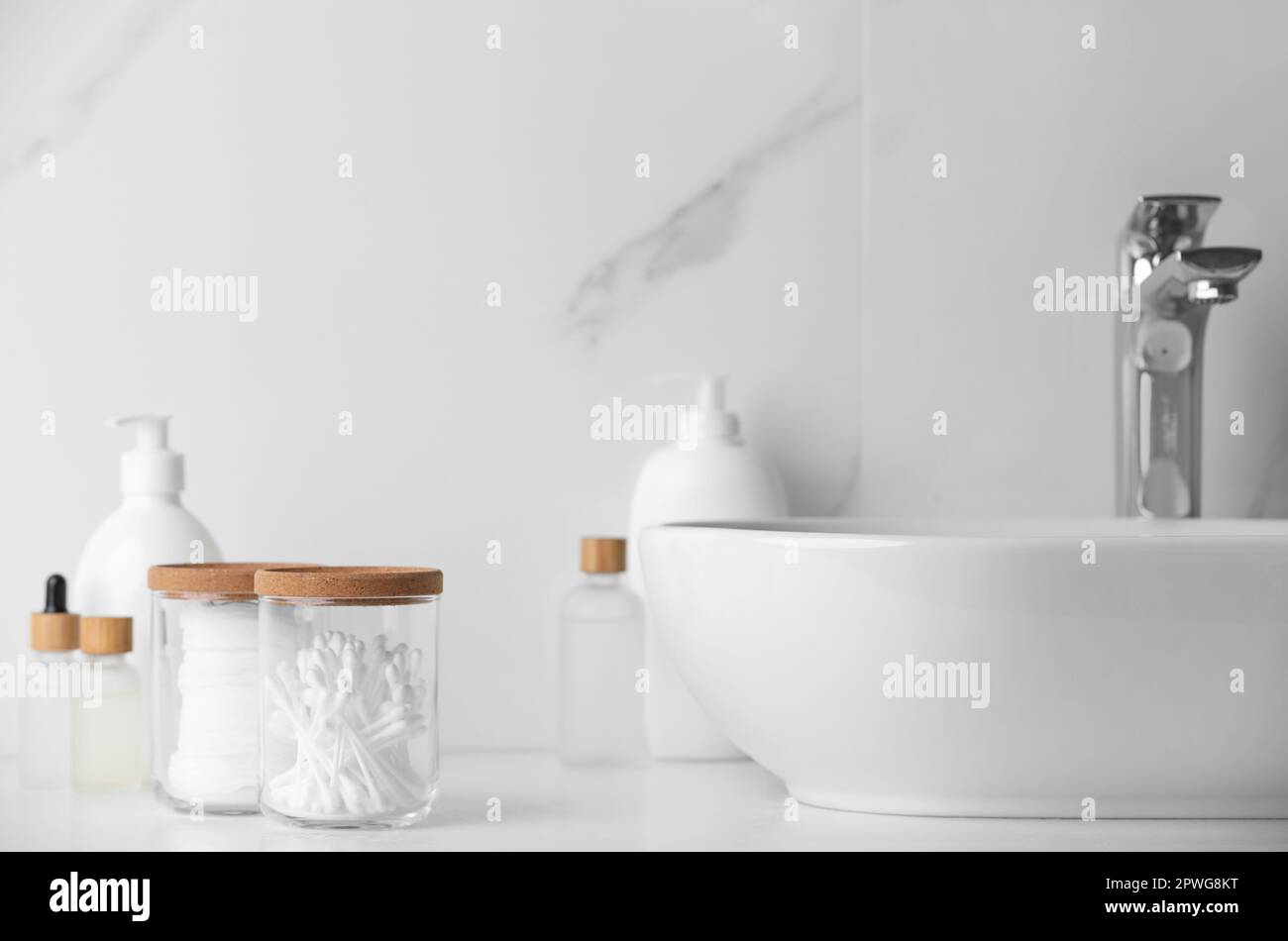 Glass jars with cotton pads and swabs near cosmetic products on white ...