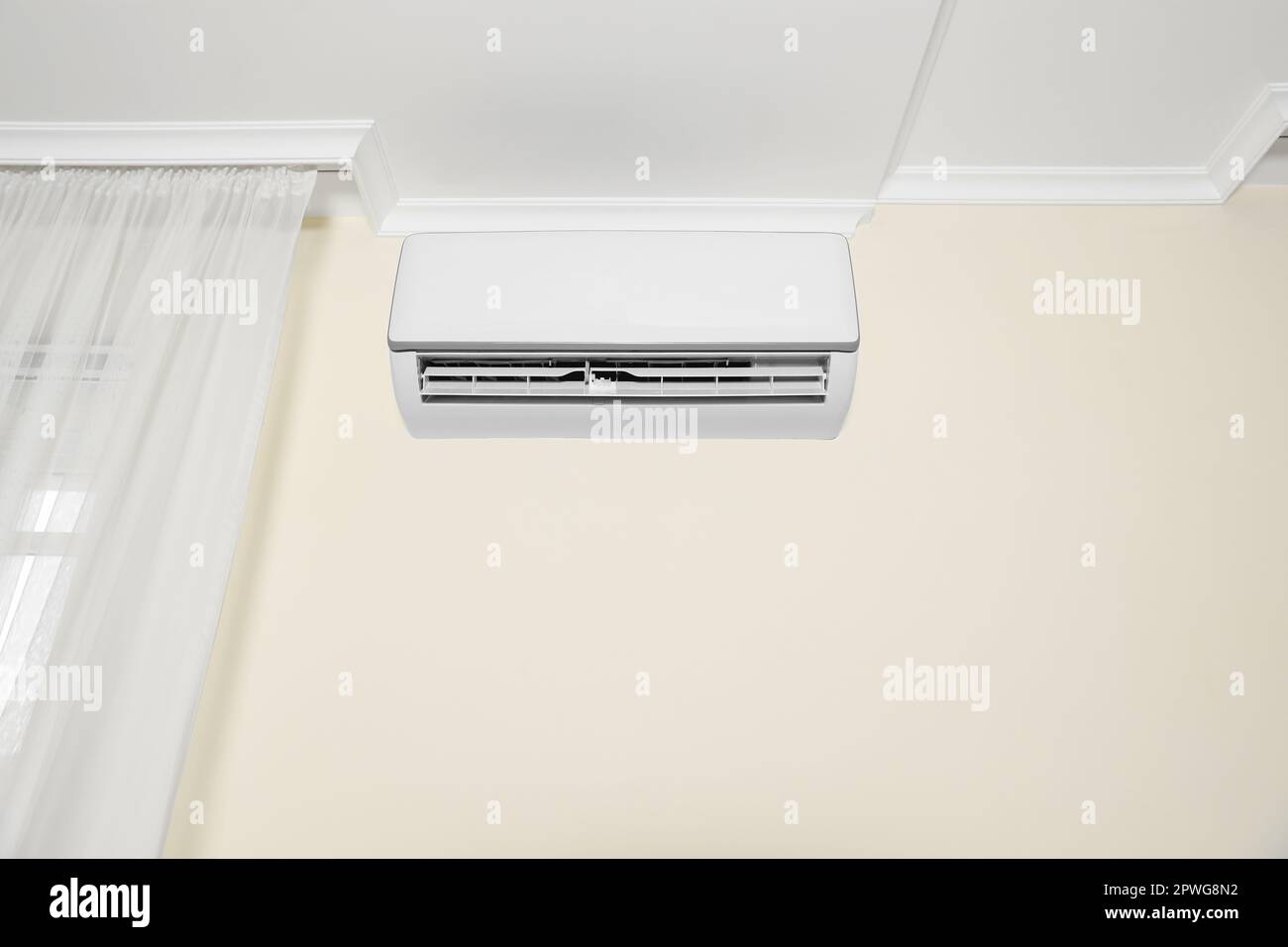 Modern air conditioner on white wall indoors Stock Photo - Alamy