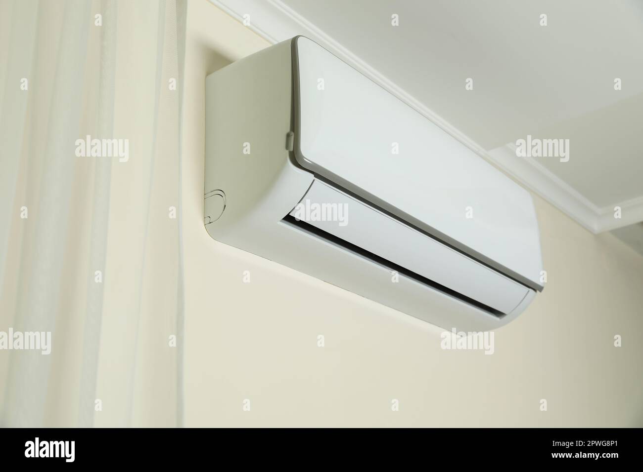 Modern air conditioner on white wall indoors Stock Photo - Alamy