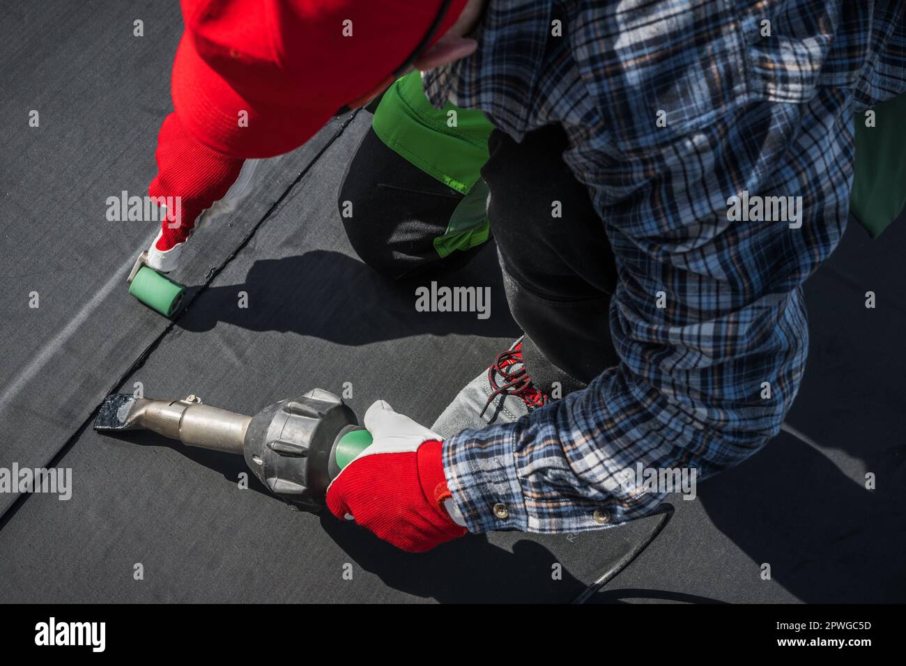 Caucasian Roofing Worker in His 40s. Hot Air Blower Using For EPDM Roof