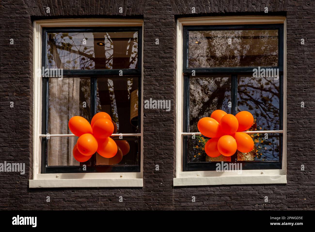 April 26, 2023, Amsterdam, Netherlands, Details of façade decoration for Kings Day, orange balloons Stock Photo