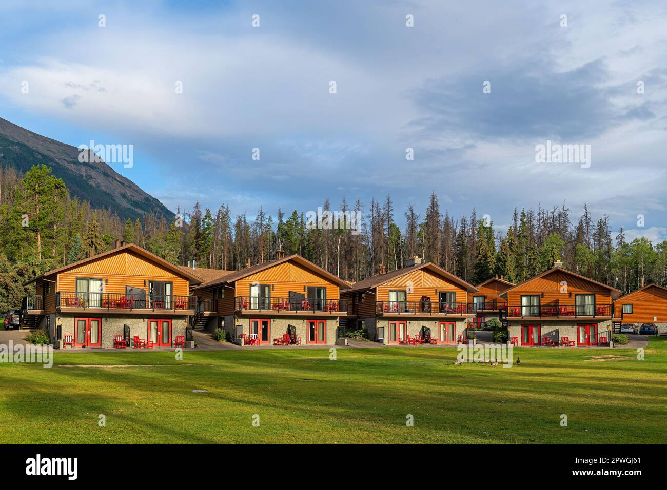 Bungalows of hotel by the Athabasca river and Canadian rockies in summer, Jasper national park, Canada. Stock Photo