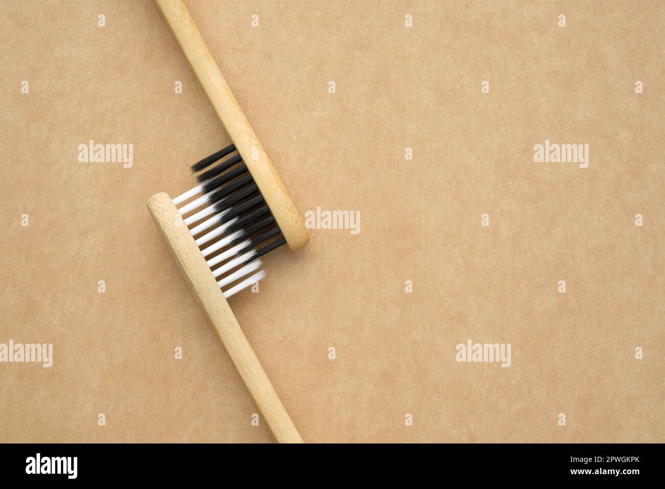 Two eco friendly wooden bamboo toothbrushes. Living together. Love concept. A conceptual of a couple toothbrushes in love. Stock Photo