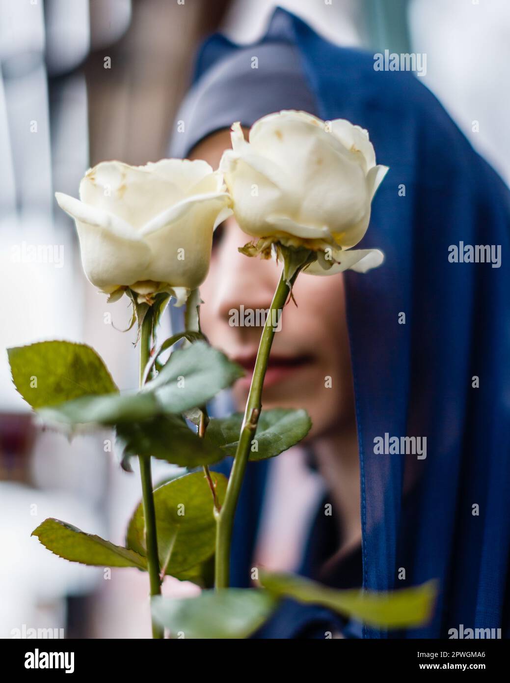 An unveiled muslim lady holding flowers Stock Photo Alamy