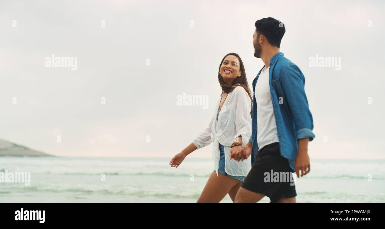 The beach, sand and her. an affectionate young couple holding hands and