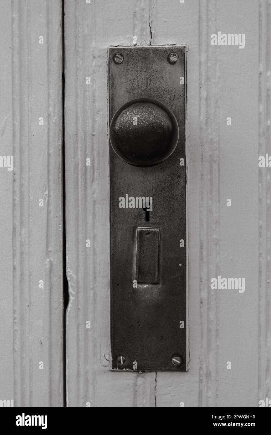 Old metal doorknob and plate in black and white Stock Photo