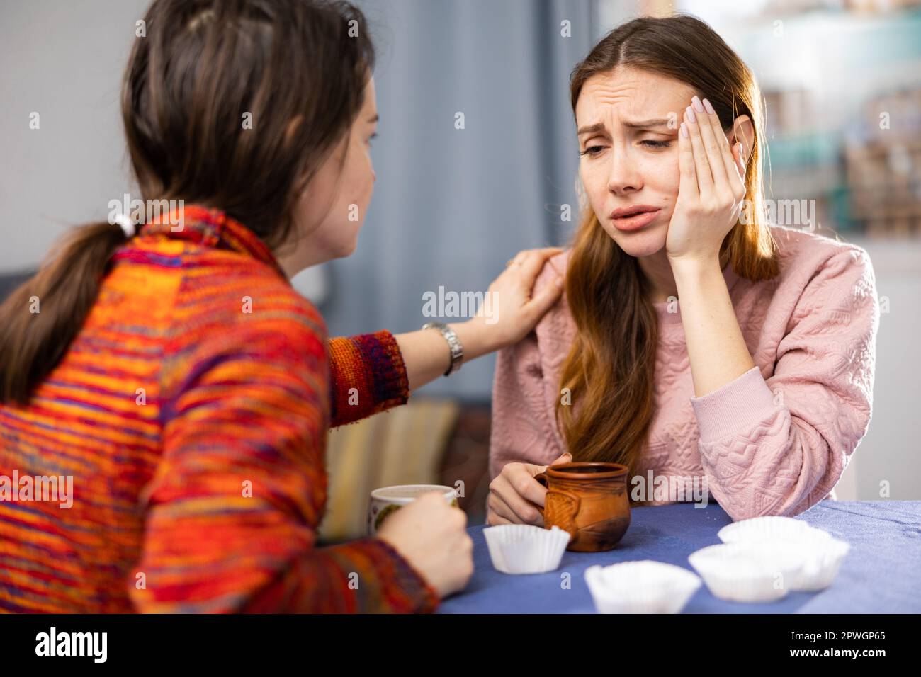 Woman comforting her depressed friend at home Stock Photo - Alamy