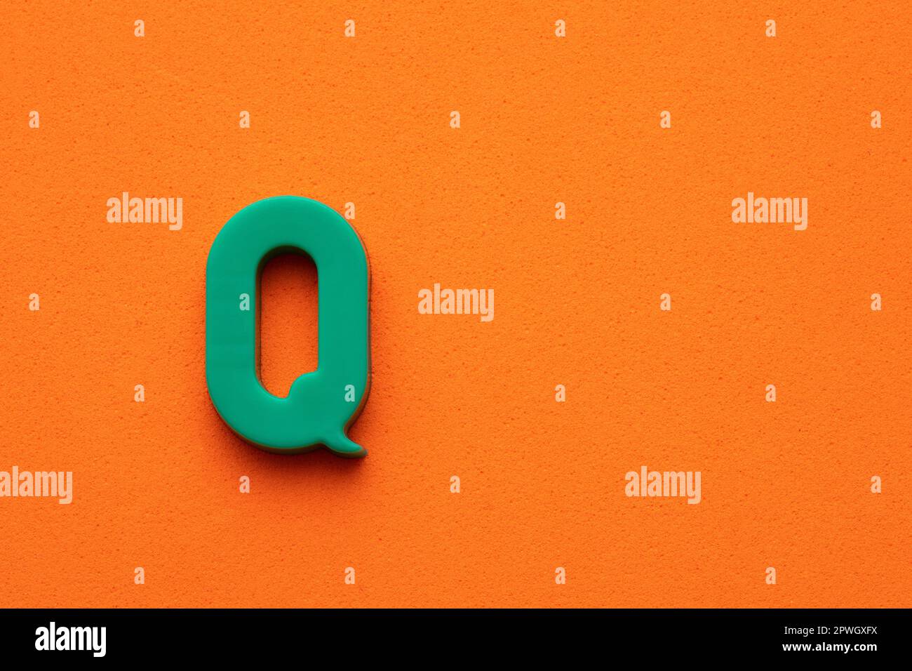 Letter Q green plastic uppercase on orange foamy background Stock Photo ...