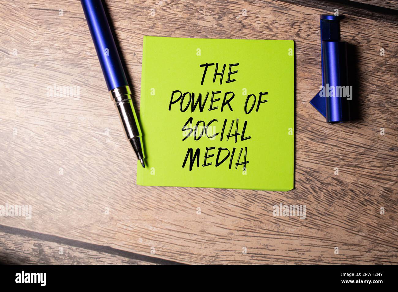 Hand with red pen. Cofee cup. Stick. Keyboard and white background. THE POWER OF SOCIAL MEDIA sign in the notepad Stock Photo
