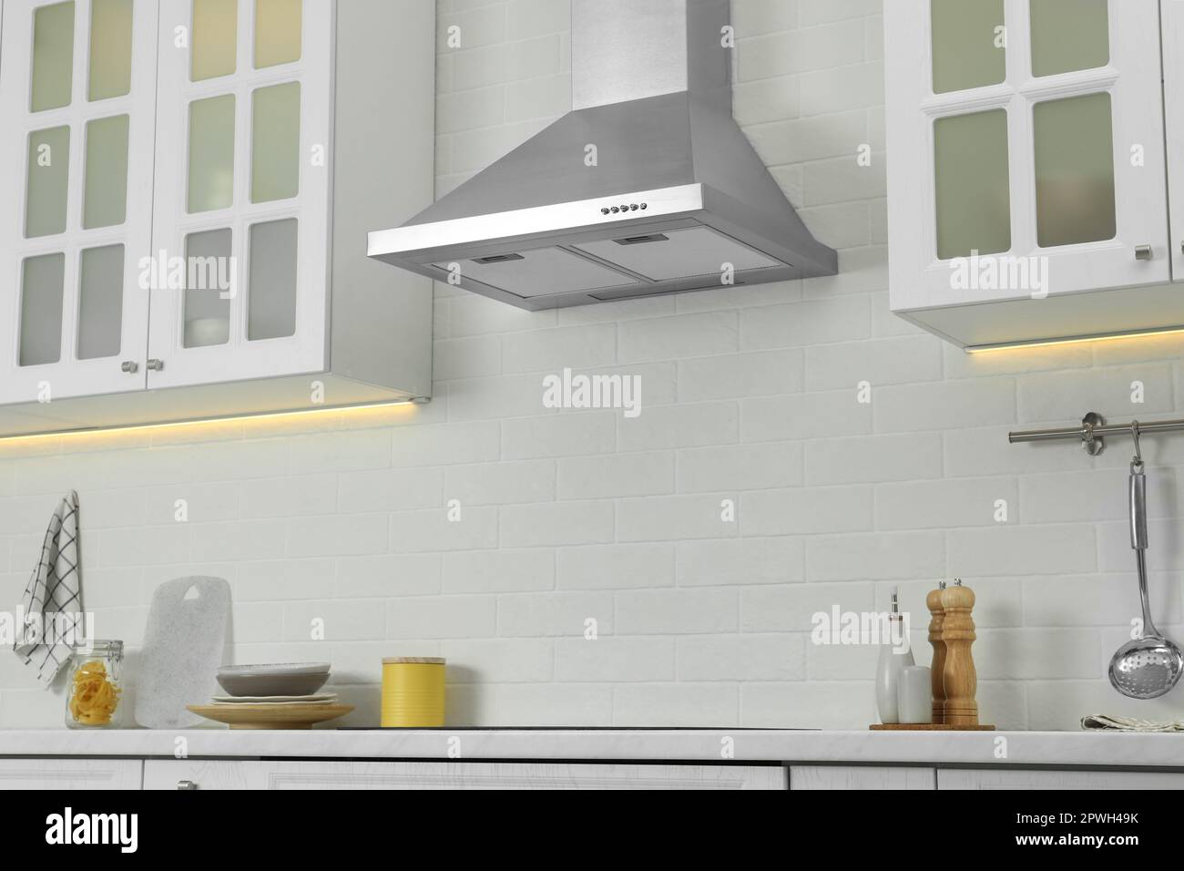 Elegant kitchen interior with modern range hood over cooktop and