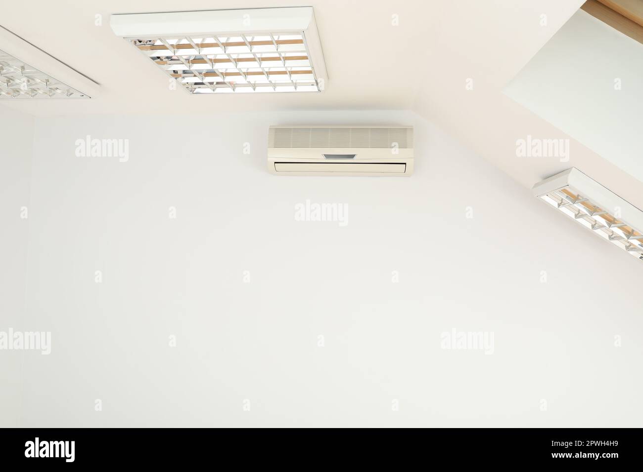 Modern air conditioner on white wall indoors Stock Photo - Alamy