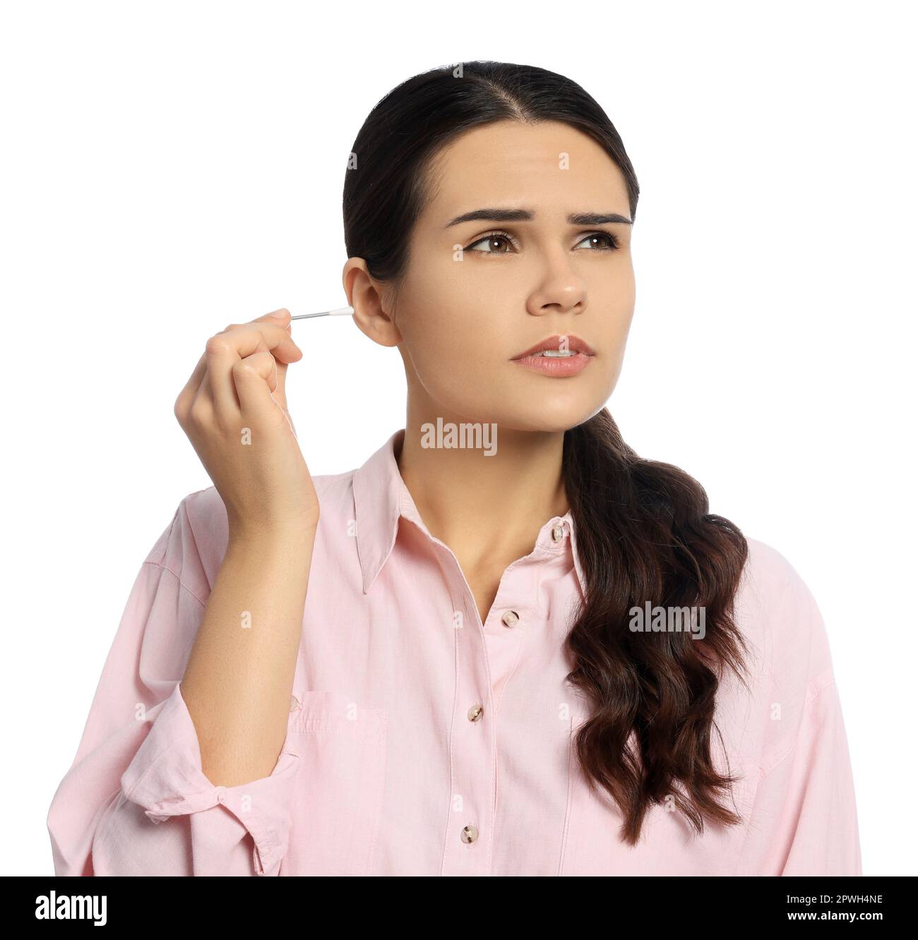 Young woman cleaning ear with cotton swab on white background Stock