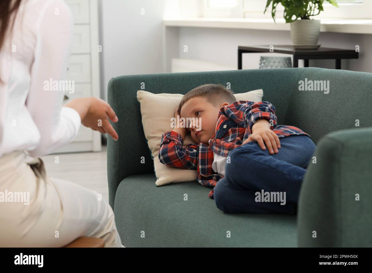 Psychologist working with unhappy little boy in office. Mental health problems Stock Photo