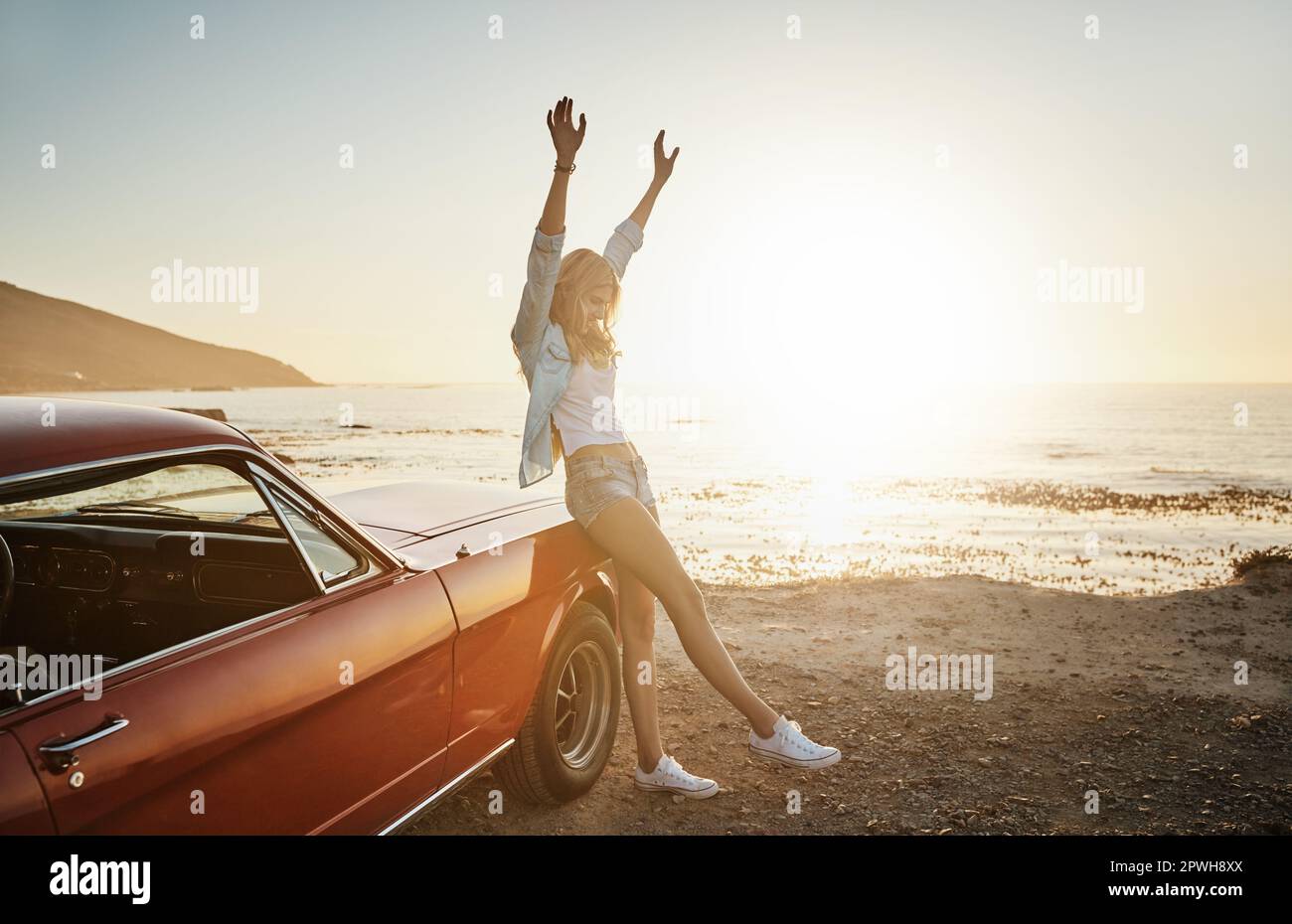 Freedom is fun. a young woman enjoying a road trip along the coast ...