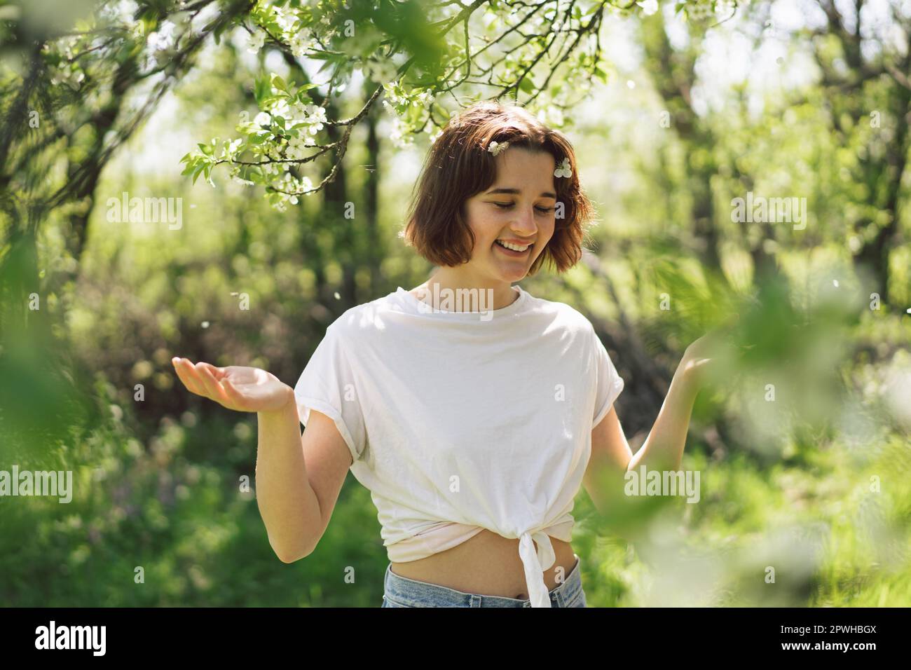 Beautiful Teenage Girl With Spring Flowers Enjoying Nature And Laughing   Beautiful Teenage Girl With Spring Flowers Enjoying Nature And Laughing On Spring Garden Girl Holding Branch Of An Cherry Tree Freedom And Happiness 2PWHBGX 