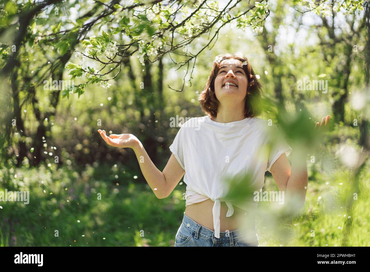 Beautiful teenage girl with spring flowers enjoying nature and laughing ...