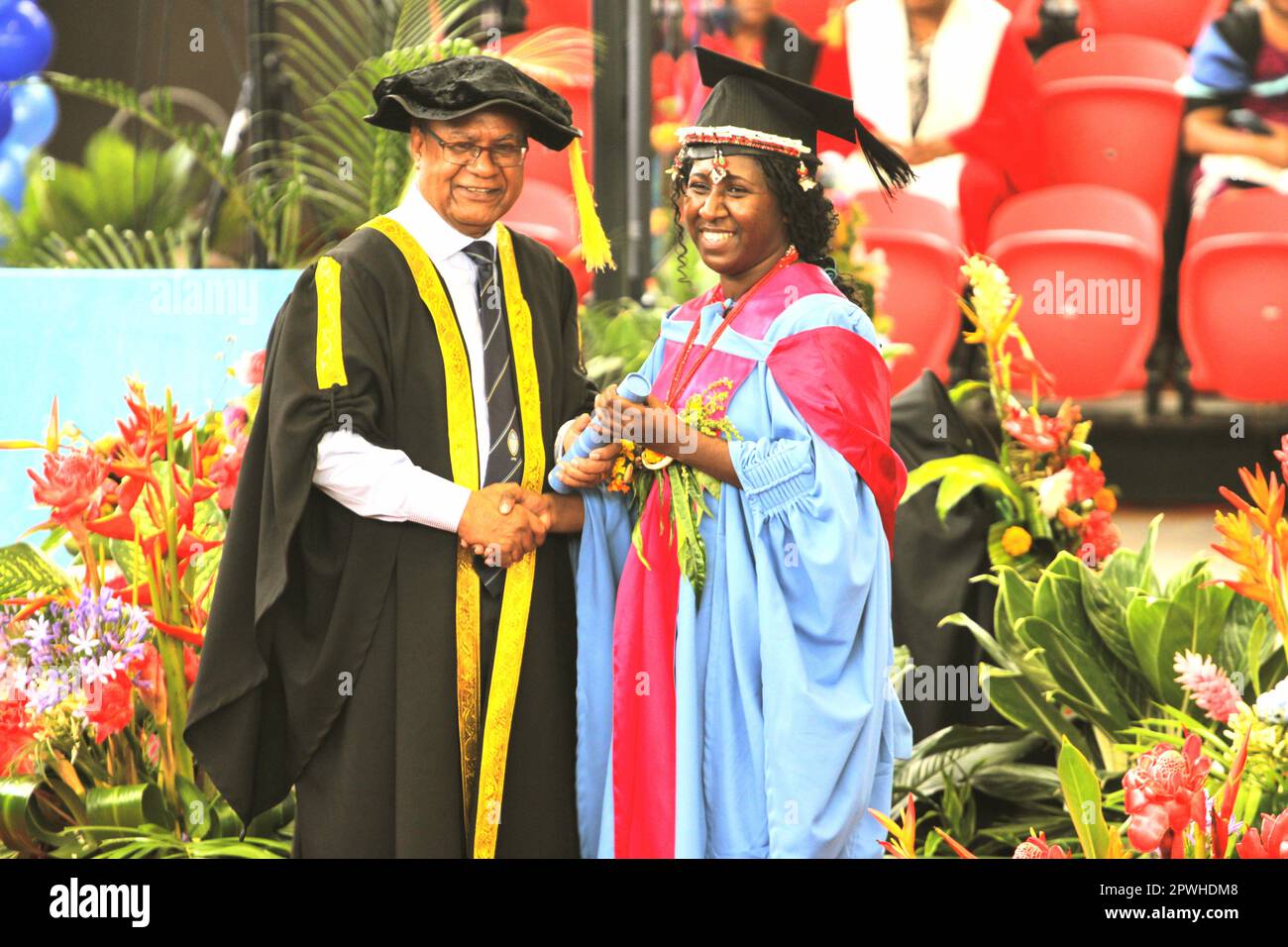 A female graduate receiving her diploma from the UPNG Vice Chancellor Stock Photo