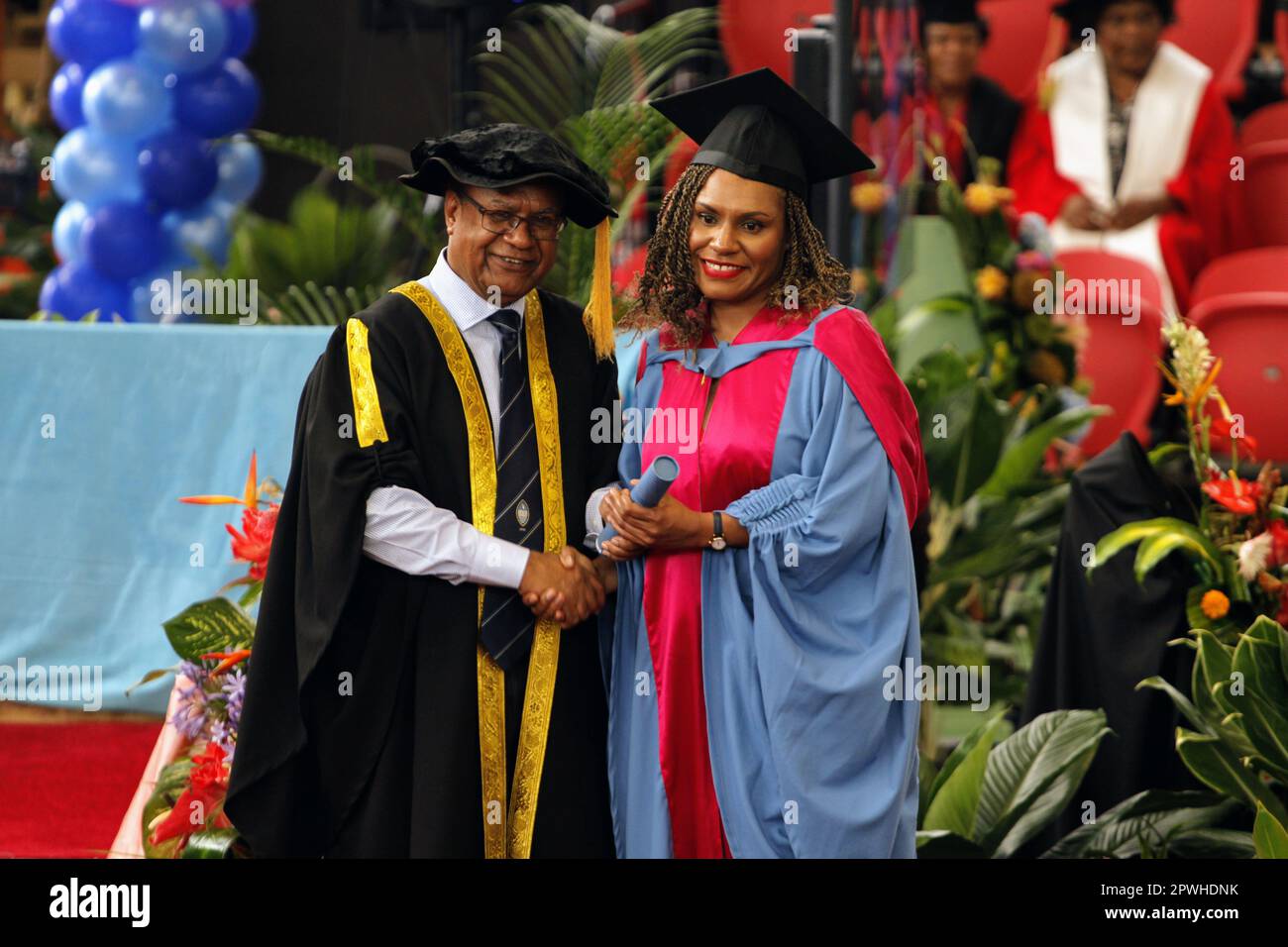 A female graduate receiving her diploma from the UPNG Vice Chancellor Stock Photo