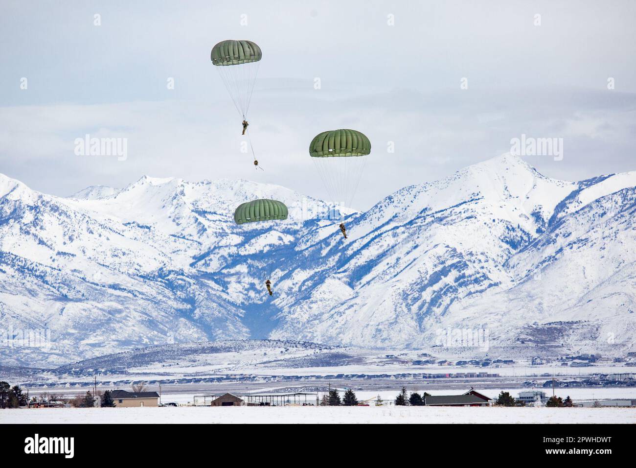 U.S. Army Paratroopers assigned to the 19th Special Forces Group (Airborne), prepare to complete the proper landing procedures to prevent the risk of injuries during an Airborne jump on February 25, 2023 near Camp Williams, Utah. Parachute landing fall known as PLF is a safety technique that allows a parachutist to land safely and to displace the energy of the body contacting the earth at high speeds. (Utah Army National Guard photo by Spc. Christopher Hall) Stock Photo