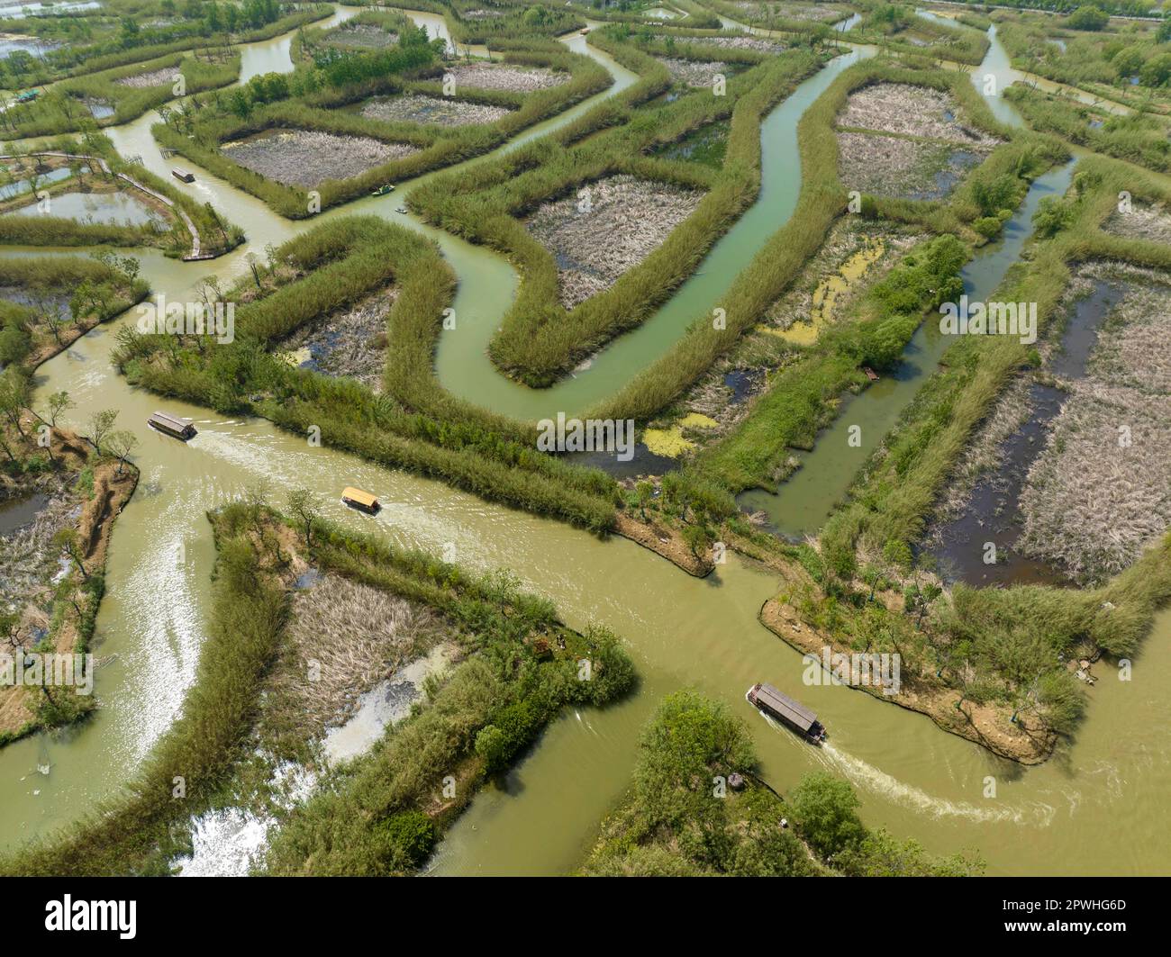 SUQIAN, CHINA - APRIL 30, 2023 - Aerial photo taken on April 30, 2023 shows tourists riding bamboo rafts and boats to play at Hongze Lake Wetland in S Stock Photo
