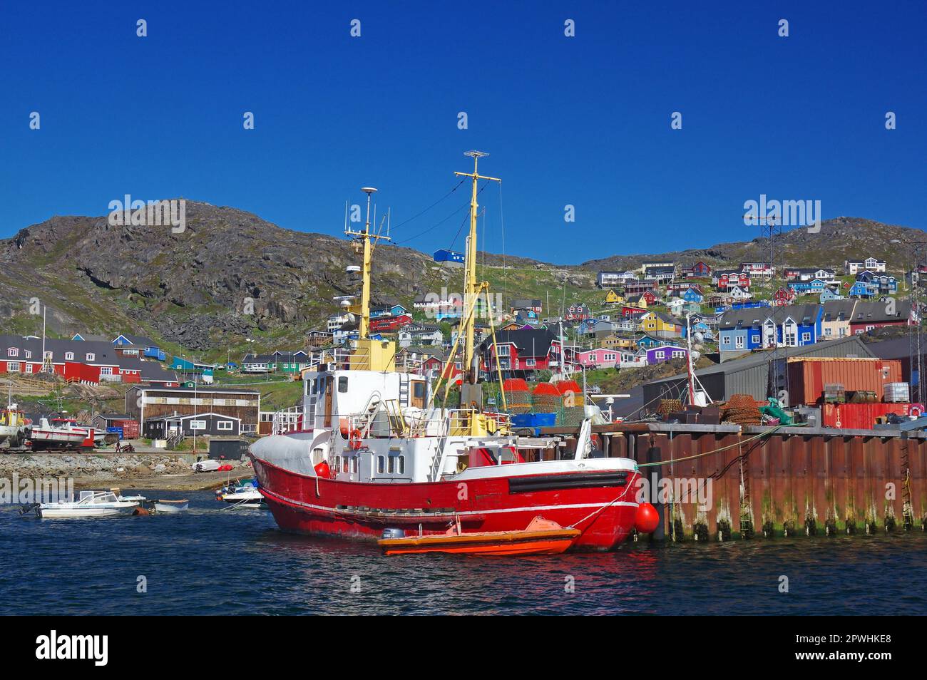 Fishing vessel and small boats, harbour and colourful houses, Qaqortoq, Kujalleq Municipality, Greenland, Denmark Stock Photo