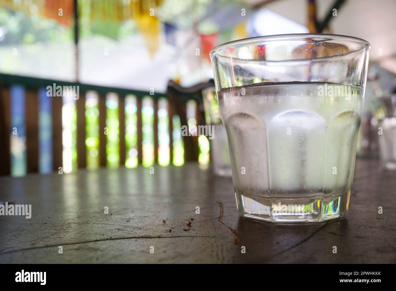 Glass of cold water in a tropical setting Stock Photo