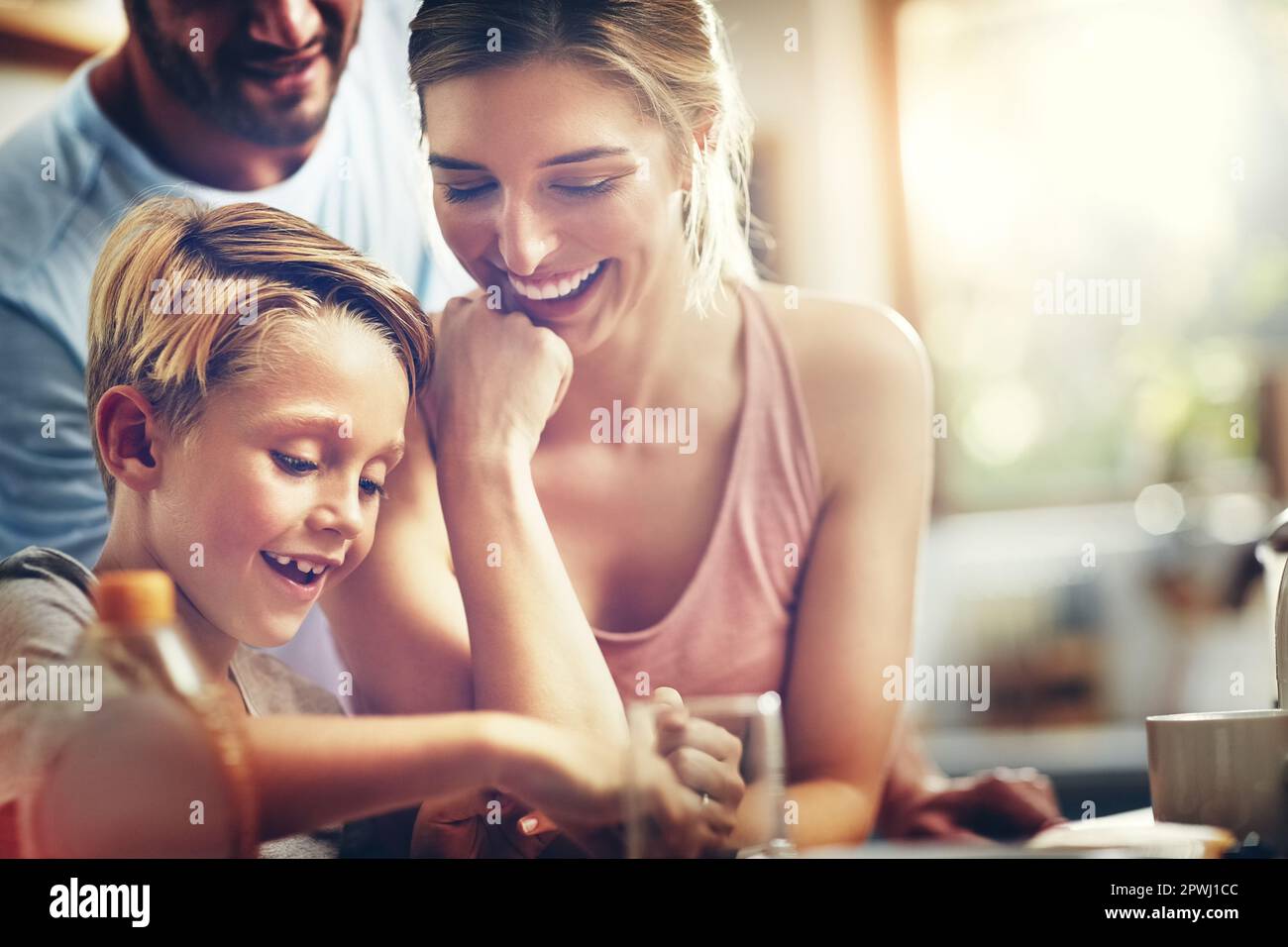 Nothing can amount to the joy family brings. a woman sitting with her son while hes having breakfast. Stock Photo