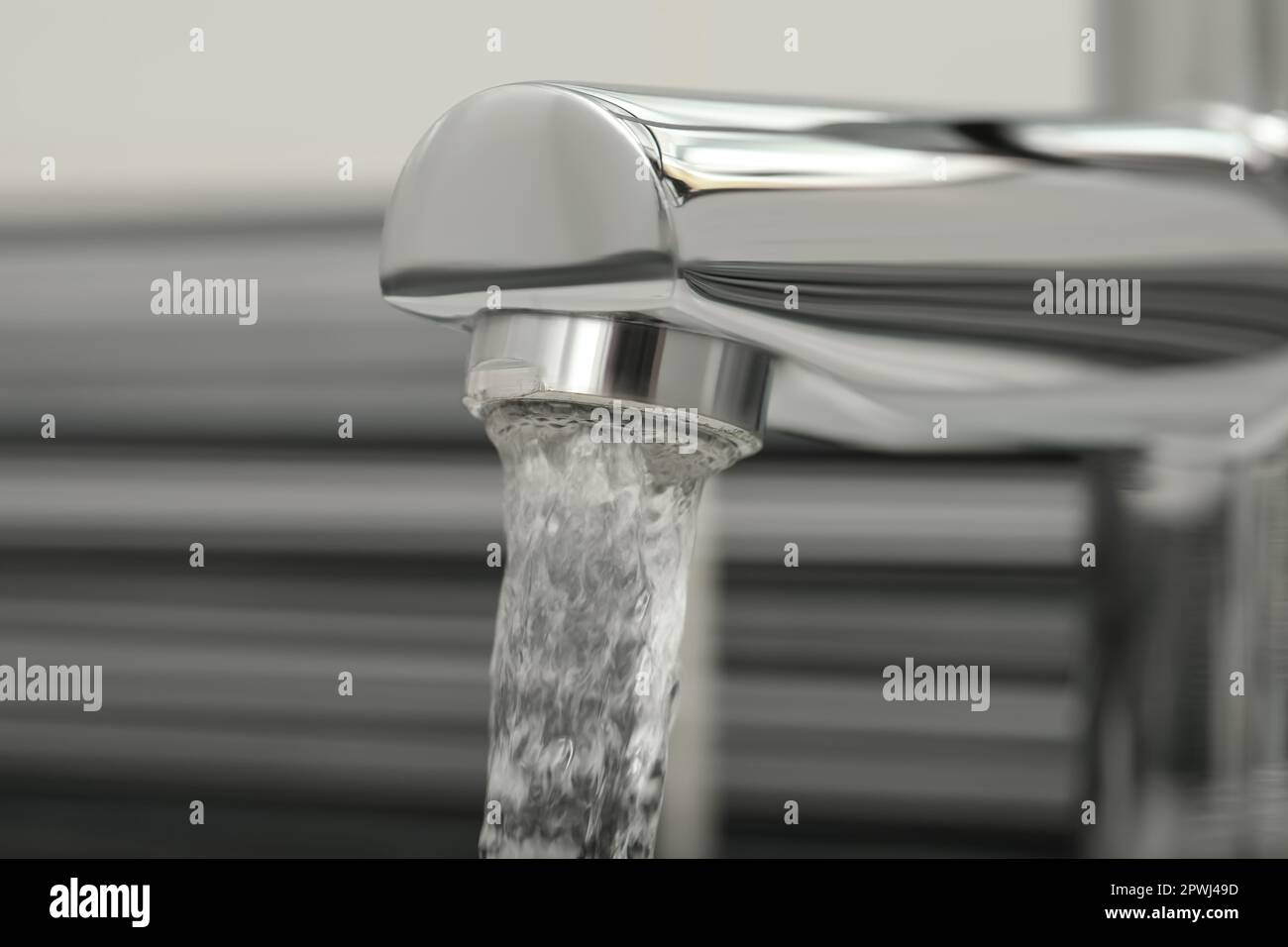Water flowing from tap on blurred background, closeup Stock Photo - Alamy